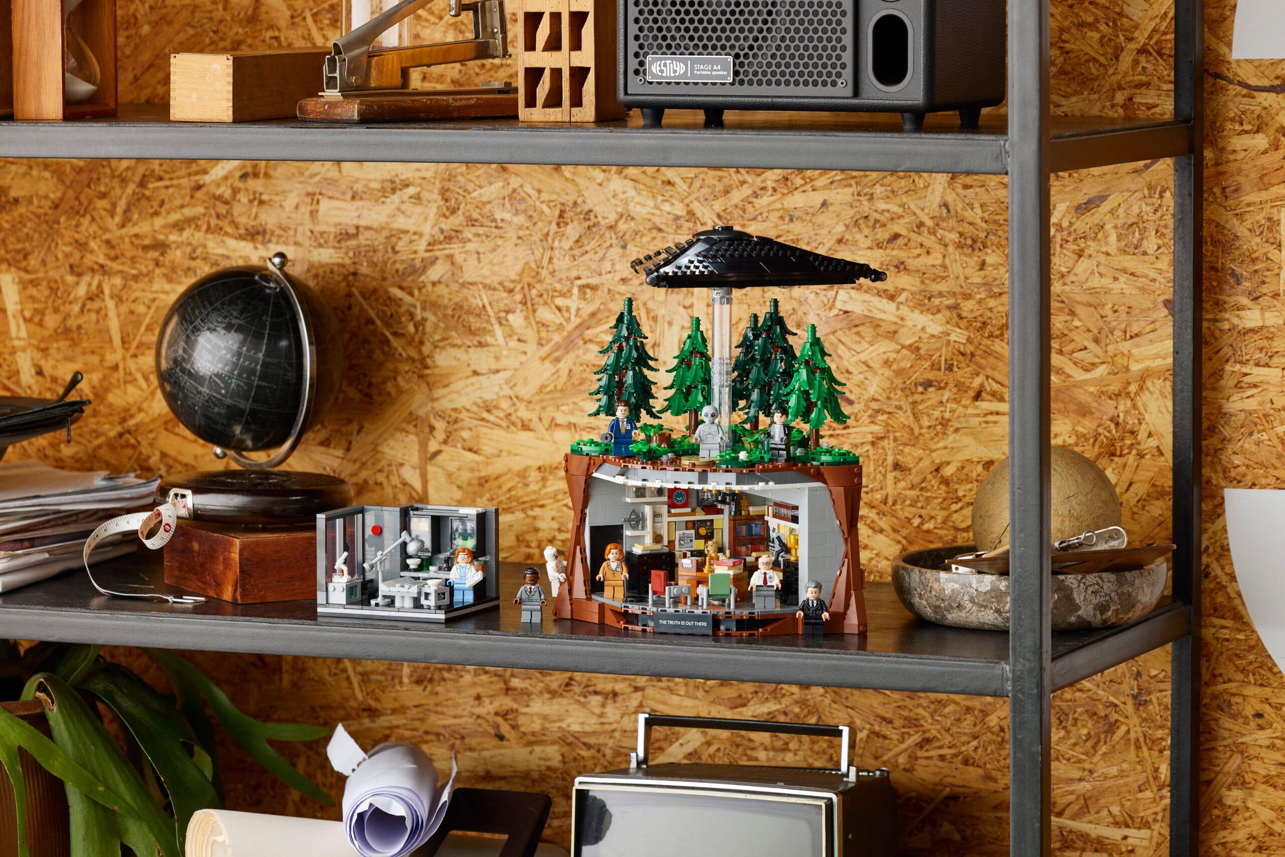 LEGO Ideas The X-Files set met Mulders kantoor, een zwevende UFO boven een bos en verschillende minifiguren op een plank