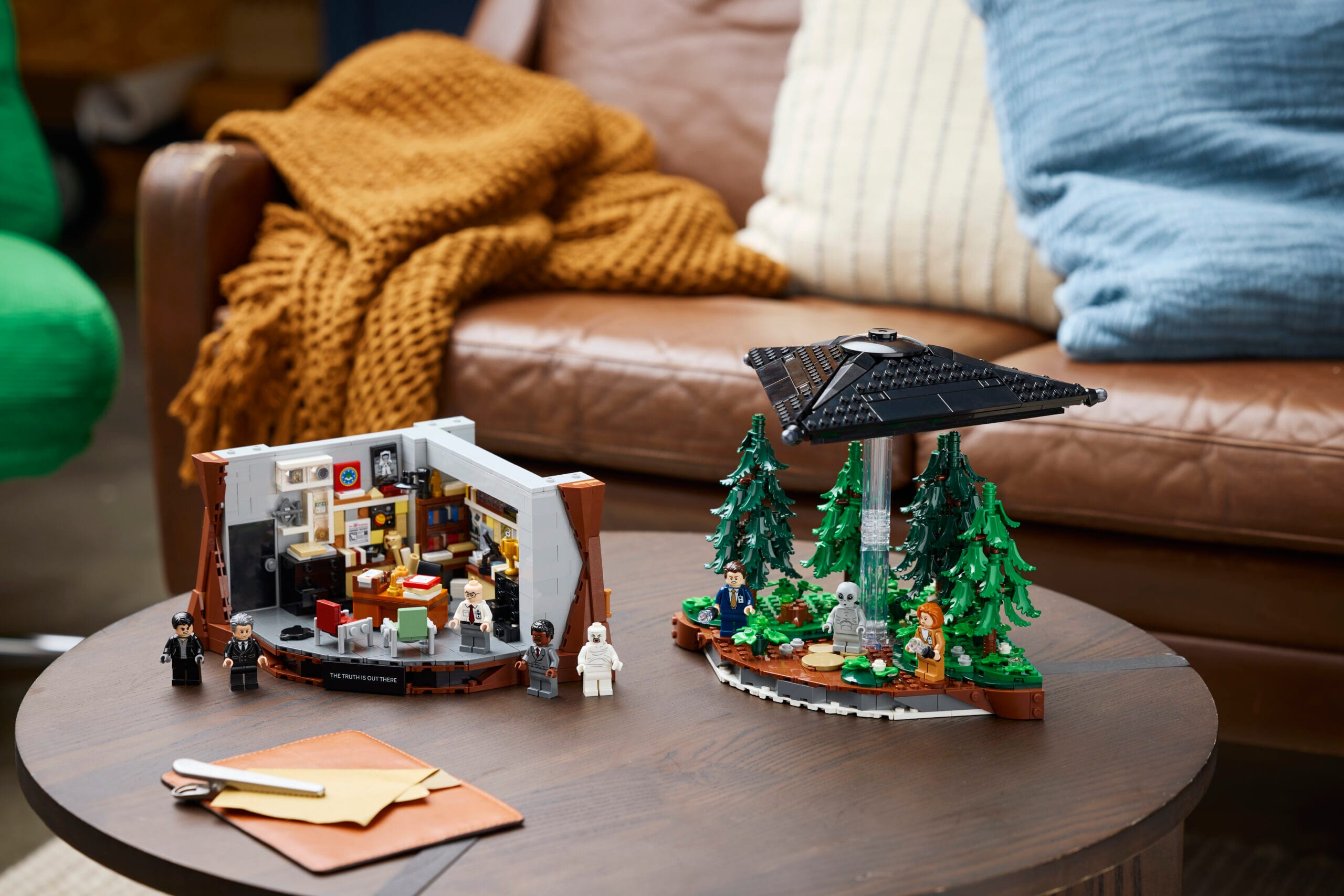 LEGO-set van The X-Files met Mulders kantoor, een zwevende UFO in een bos en diverse minifiguren op een tafel
