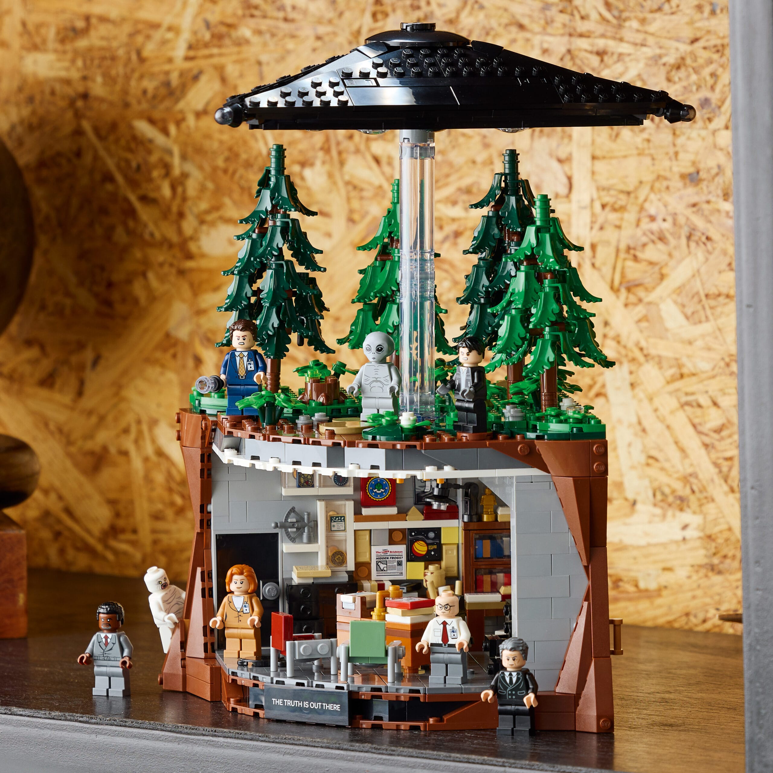 LEGO Ideas The X-Files set met Mulders kantoor onderaan en een zwevende UFO in een bosrijke omgeving bovenaan