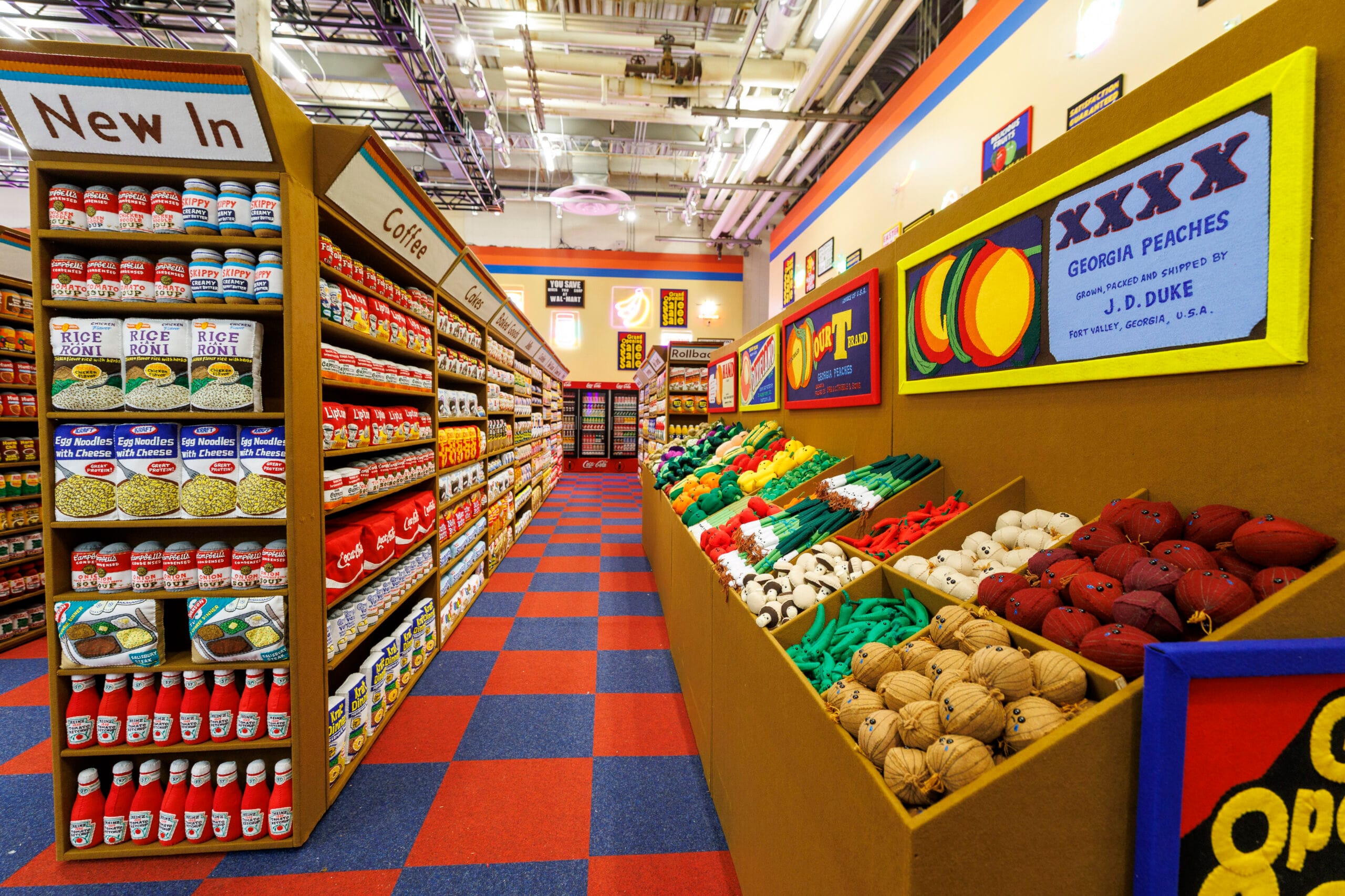 Overzicht van een kleurrijke supermarkt gevuld met duizenden handgemaakte vilten producten in schappen en bakken