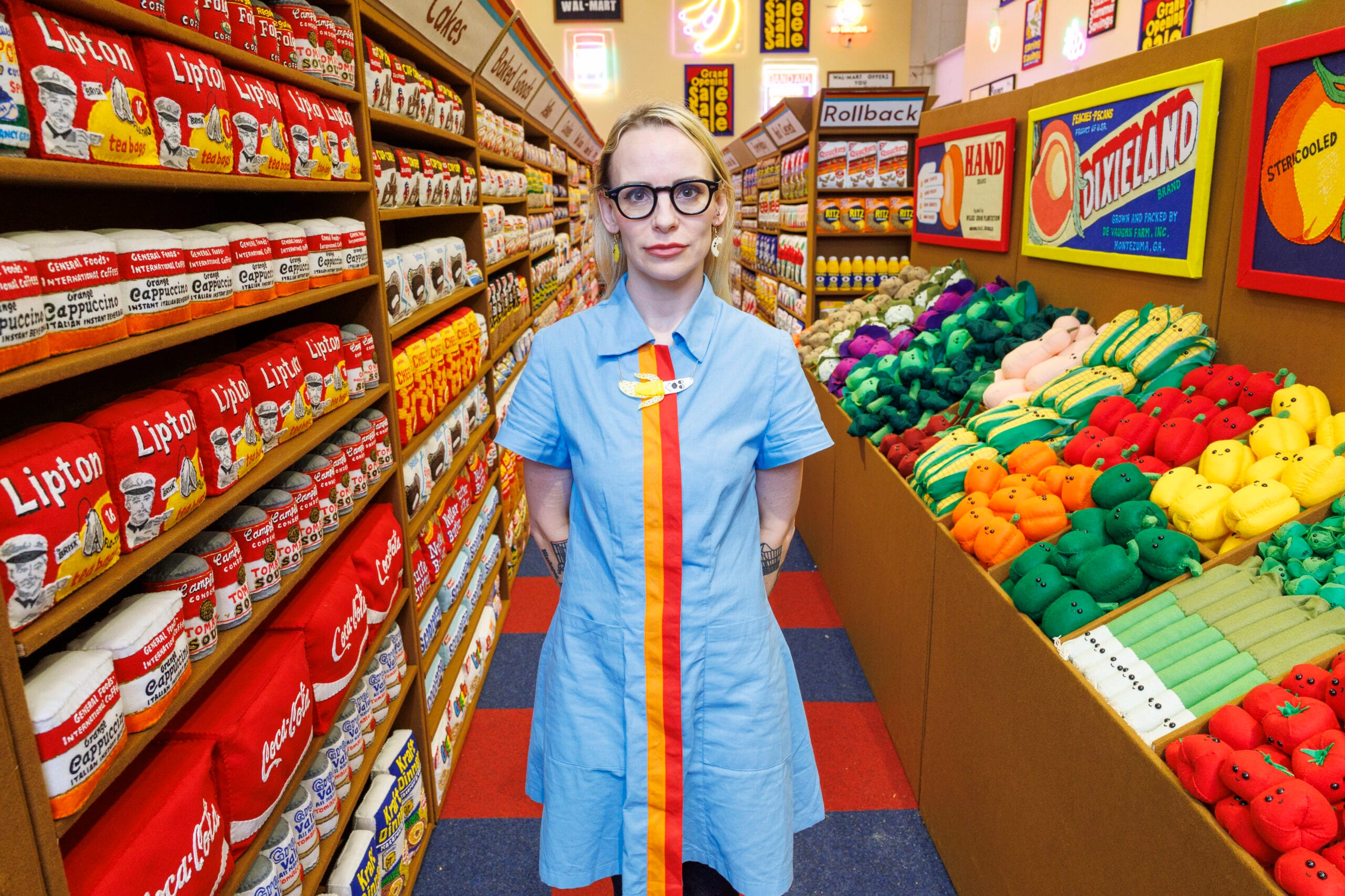 Kunstenares Lucy Sparrow staat in haar vilten supermarkt tussen schappen vol handgemaakte producten van vilt