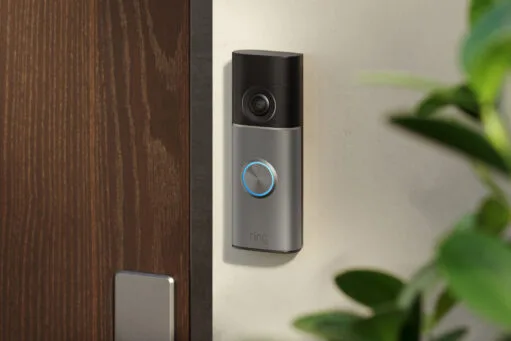 Een Ring Video Doorbell gemonteerd op een muur naast een houten voordeur