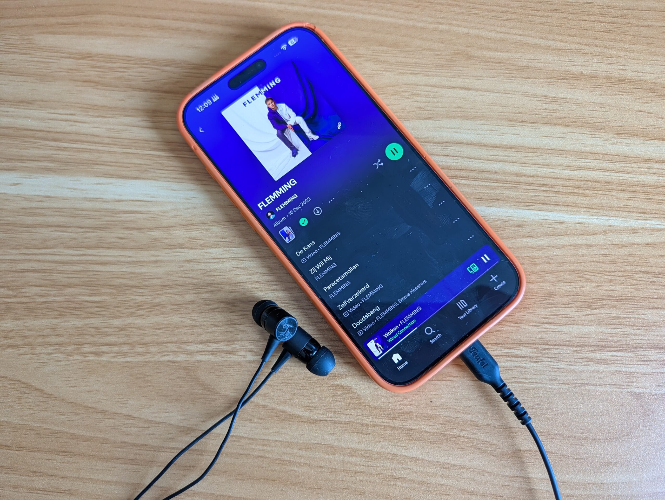 De Teufel Move 2 oordopjes aangesloten via de USB-C poort op een smartphone die muziek afspeelt via Spotify