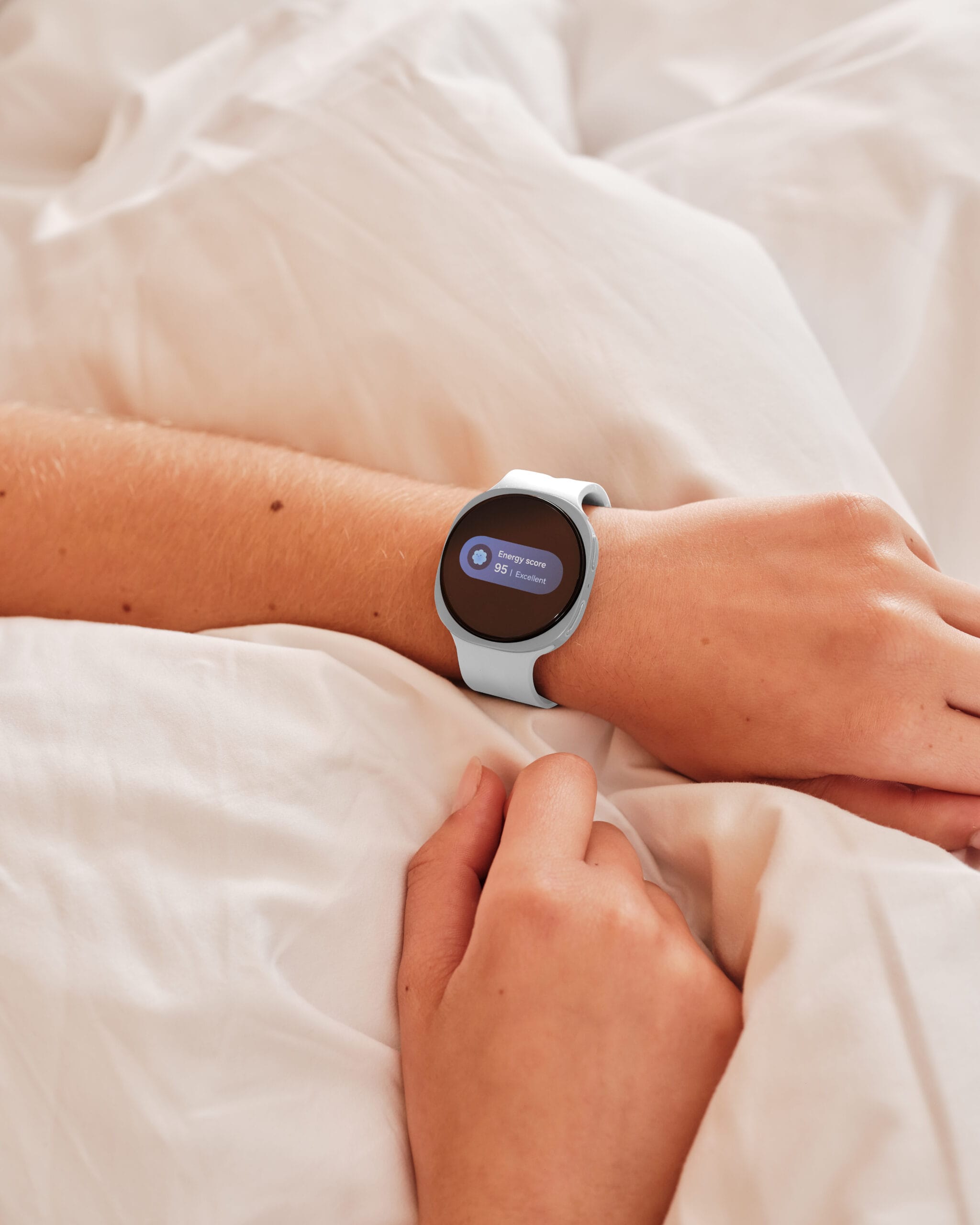 Iemand in bed met een Galaxy Watch9 die een Energy score van 95 en de status Excellent toont