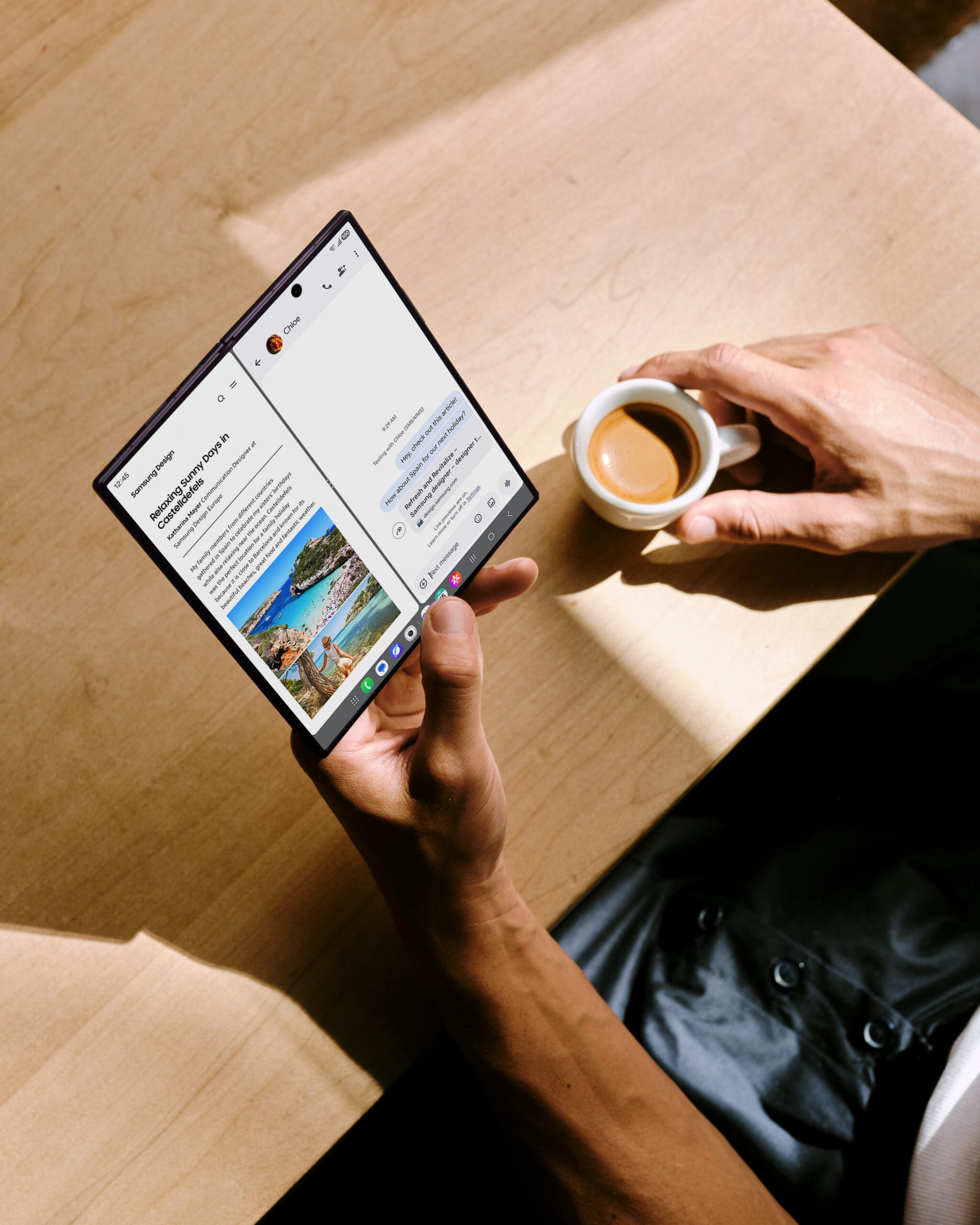 Bovenaanzicht van een uitgeklapte Samsung Galaxy Z Fold8 die wordt vastgehouden boven een tafel met een kop koffie