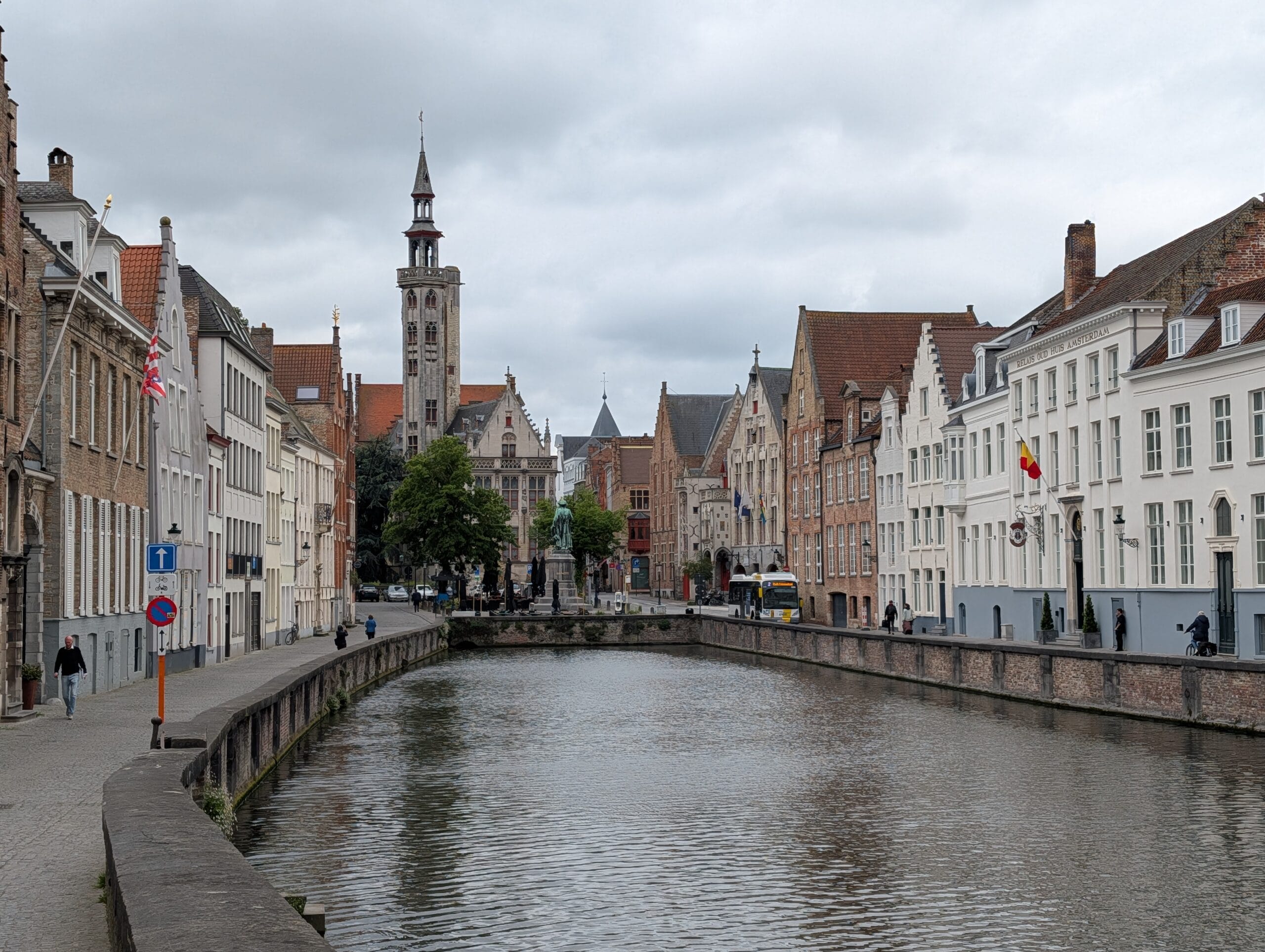 Gezicht op de Spiegelrei in Brugge met historische trapgevels, de Poortersloge en het standbeeld van Jan van Eyck