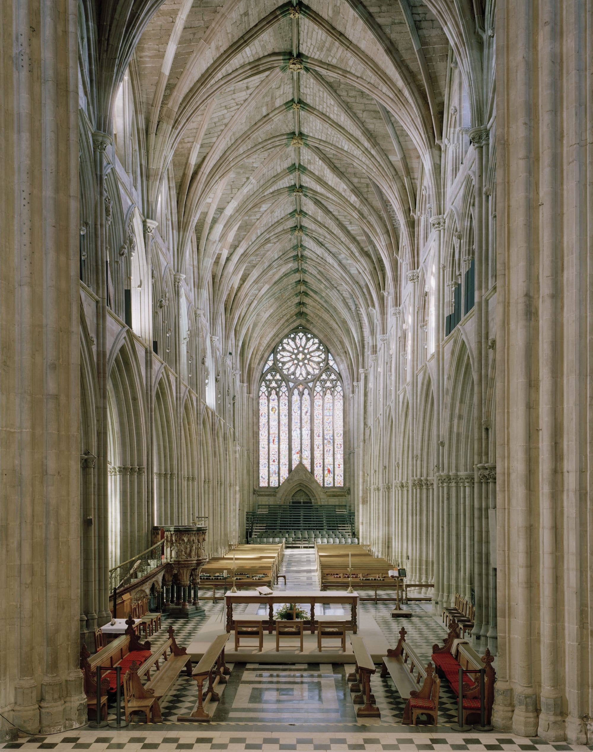 Het middenschip van Worcester Cathedral met een hoog gewelfd plafond, stenen bogen en een groot gebrandschilderd raam