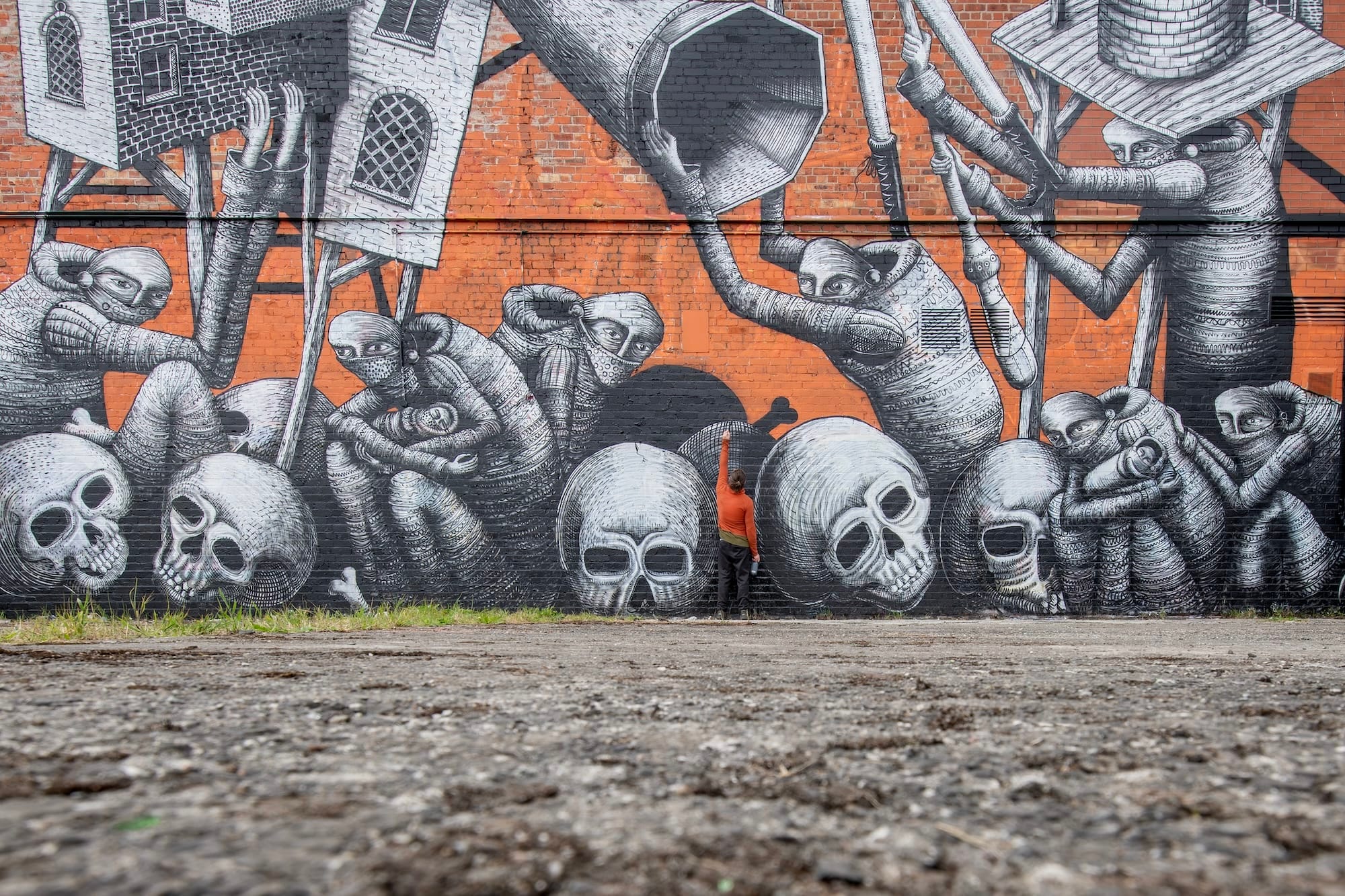 Zwart-witte muurschildering van Phlegm met hybride figuren, schedels en houten constructies op een bakstenen muur
