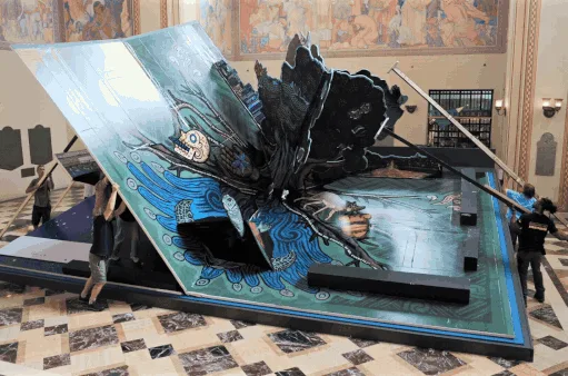 Mensen installeren een gigantisch pop-up boek met kleurrijke illustraties in een grote hal