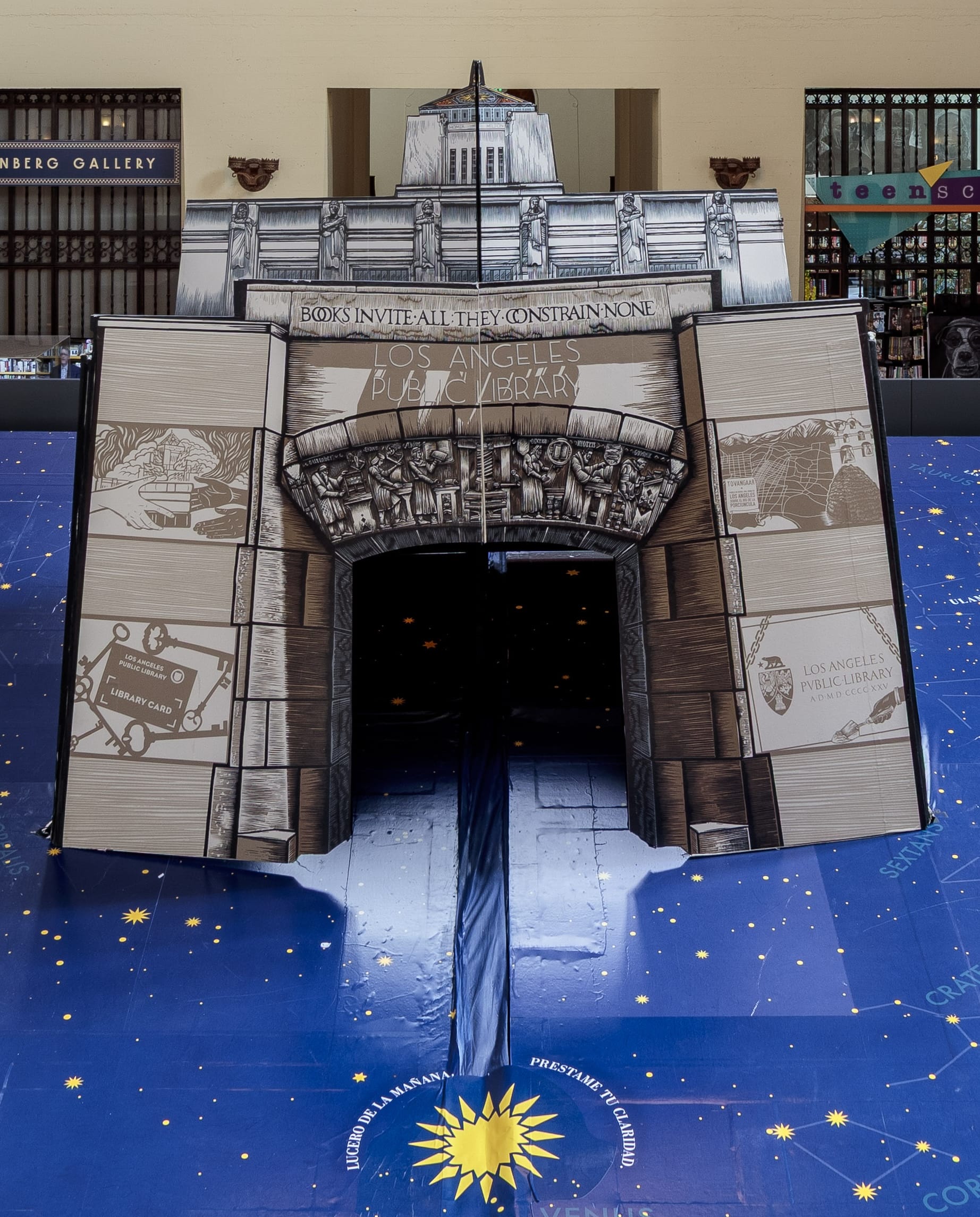 Een gigantisch pop-upboek dat de voorgevel van de Los Angeles Public Library verbeeldt op een blauwe sterrenhemel-ondergrond