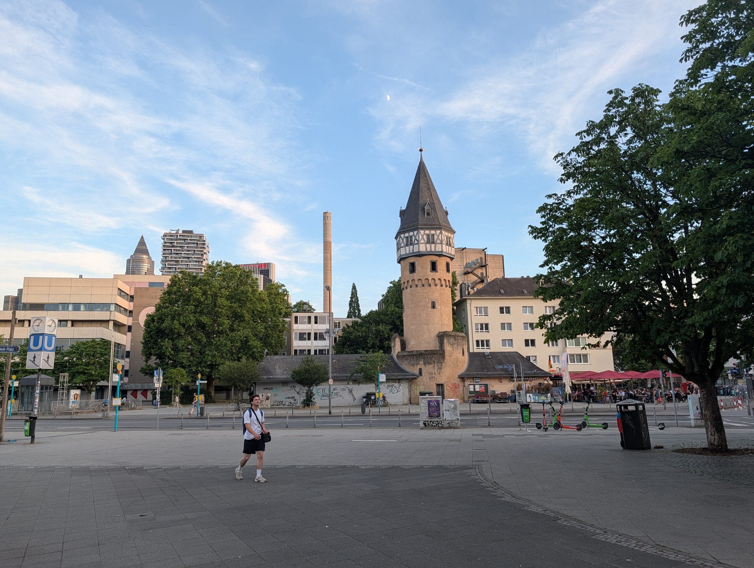 De historische toren Bockenheimer Warte op een plein in de wijk Bockenheim, met op de achtergrond moderne hoogbouw