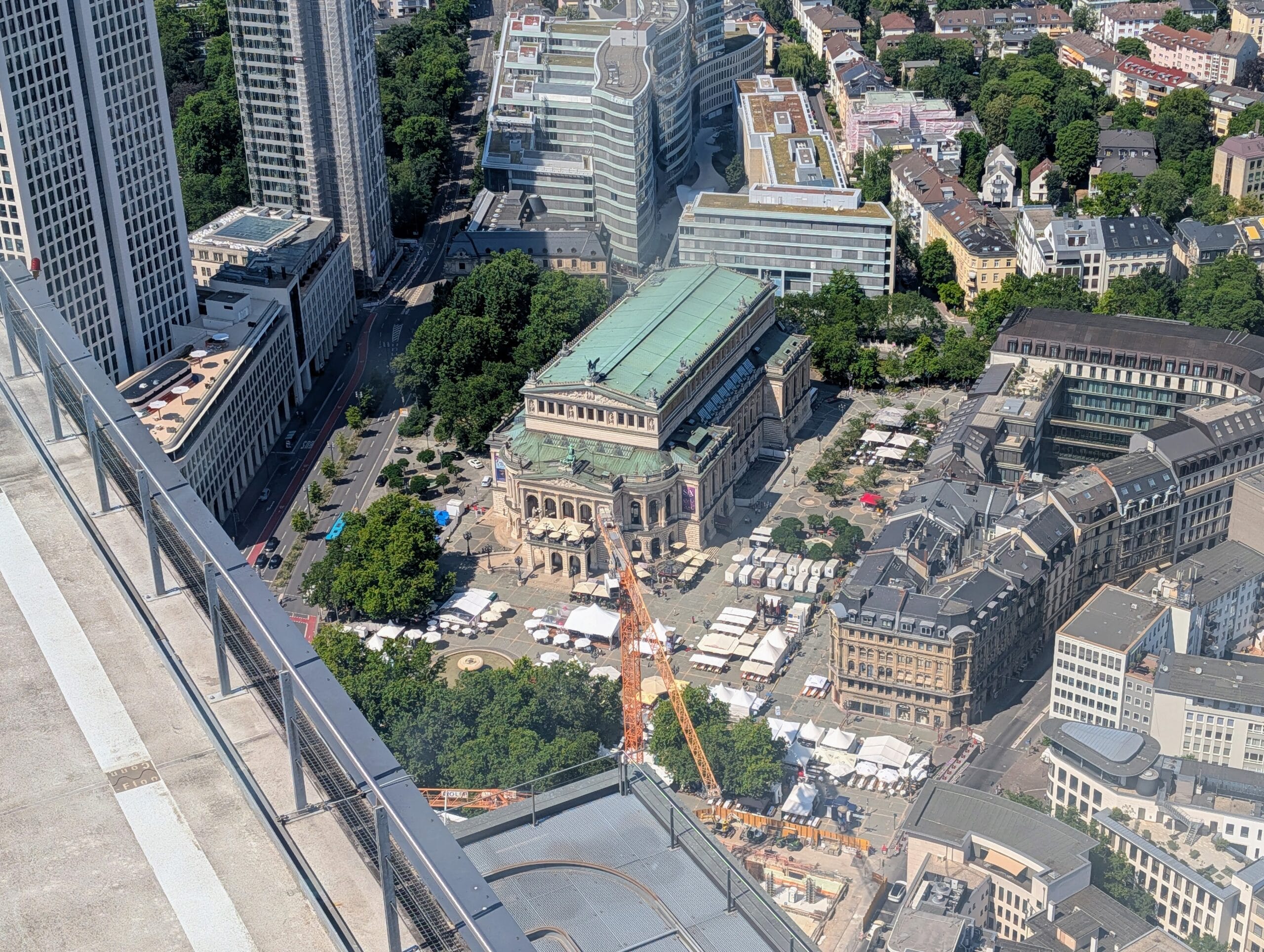 Bovenaanzicht vanaf een wolkenkrabber op de Alte Oper en het omliggende plein met witte marktkraampjes in Frankfurt