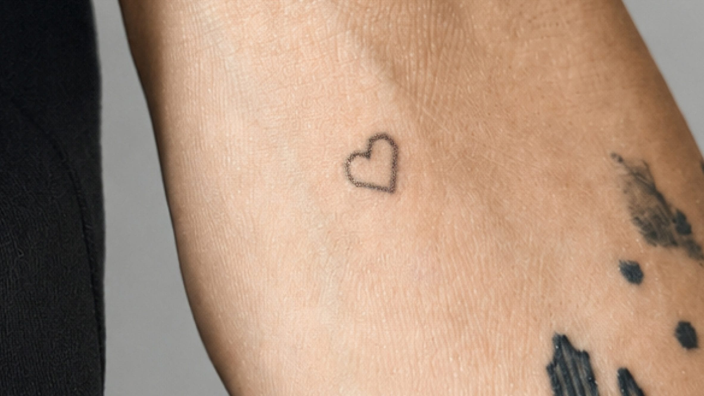 Een kleine, subtiele tatoeage van een hartje op een arm, gezet met de microdot-technologie van CipherX