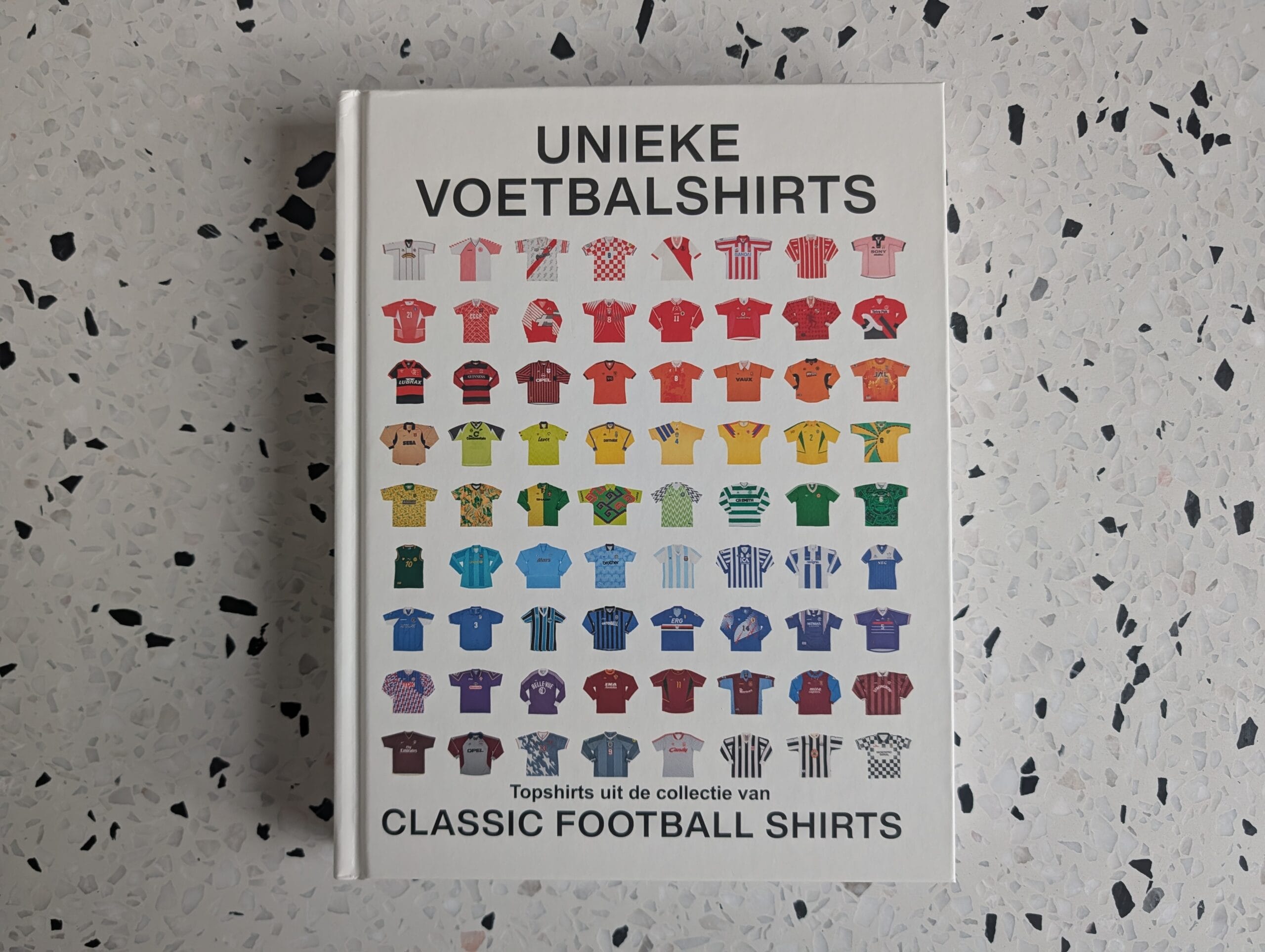 Boekomslag van Unieke Voetbalshirts: Topshirts uit de collectie van Classic Football Shirts, met rijen kleurrijke miniatuurshirts