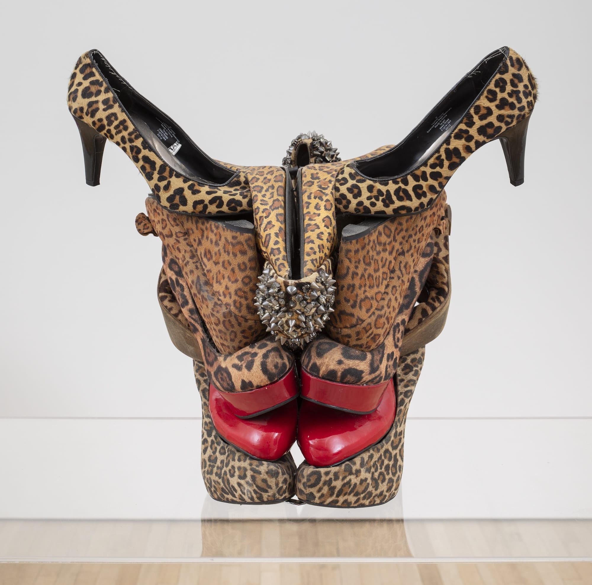Een sculptuur van een stierenschedel gemaakt van diverse schoenen met luipaardprint en rode pumps