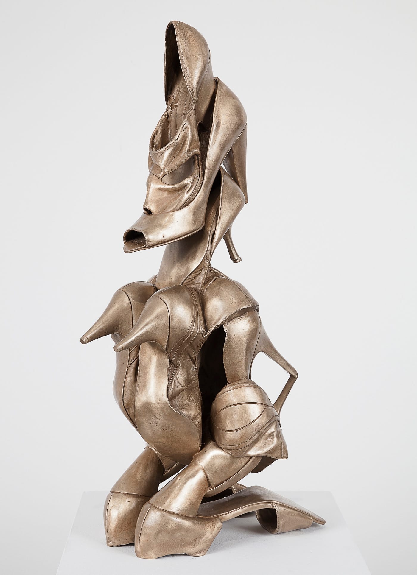 Bronzen sculptuur van een menselijke figuur, volledig opgebouwd uit verschillende soorten damesschoenen met hoge hakken