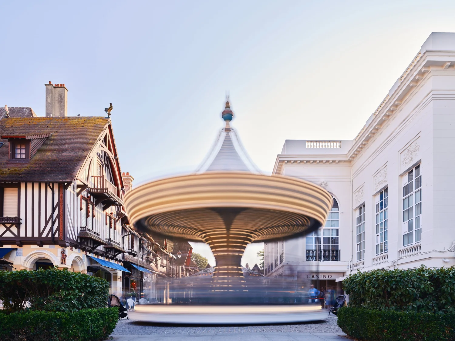 Draaiende carrousel met bewegingsonscherpte op een plein in Deauville tussen traditionele en witte gebouwen