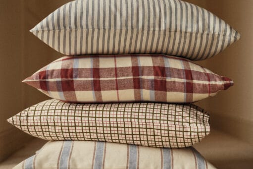 Stapel van vier kussens met verschillende patronen: strepen, ruiten en een fijn raster in neutrale en aardse tinten, uit de Essentials collectie van Bonsoirs