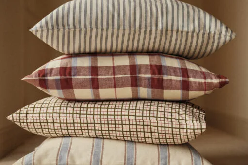 Stapel van vier kussens met verschillende patronen: strepen, ruiten en een fijn raster in neutrale en aardse tinten, uit de Essentials collectie van Bonsoirs