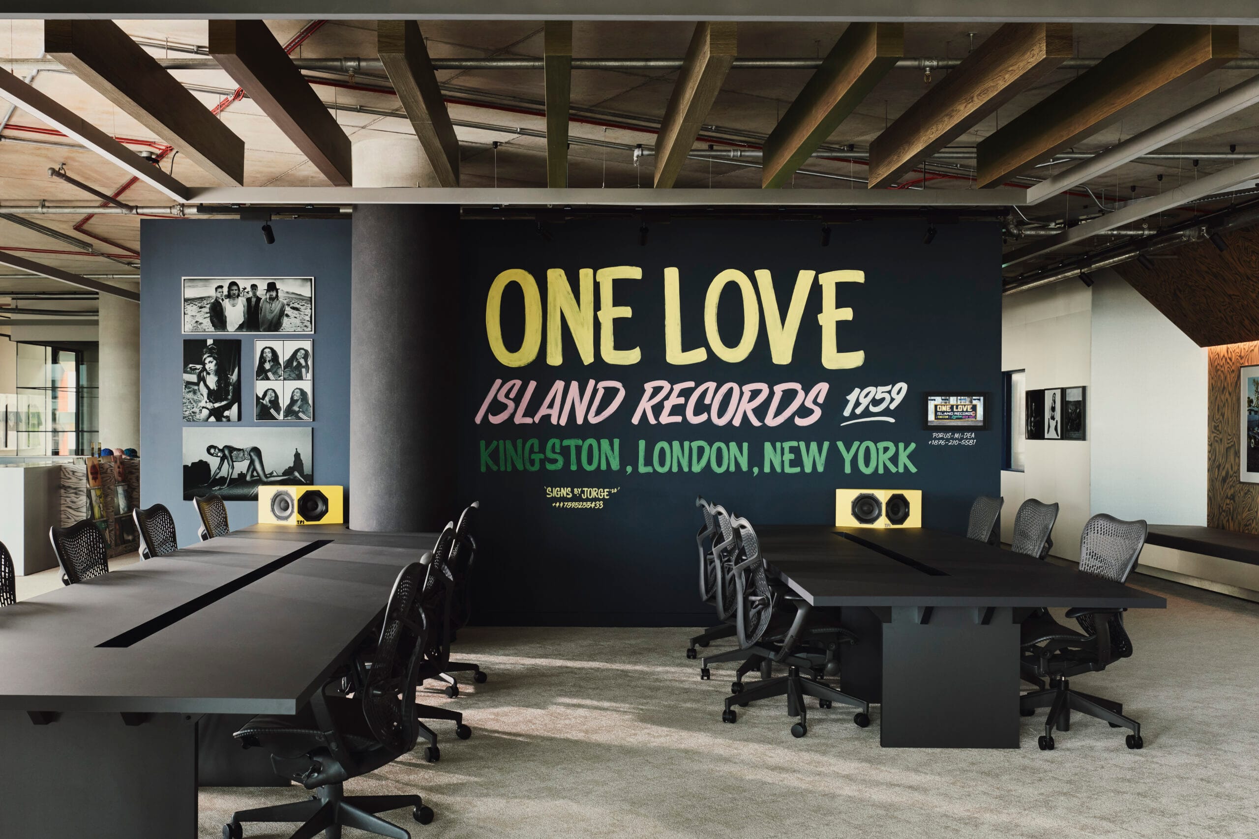 Handgeschilderde muurschildering van Jorge Jacobs met de tekst One Love Island Records 1959 in een modern kantoor