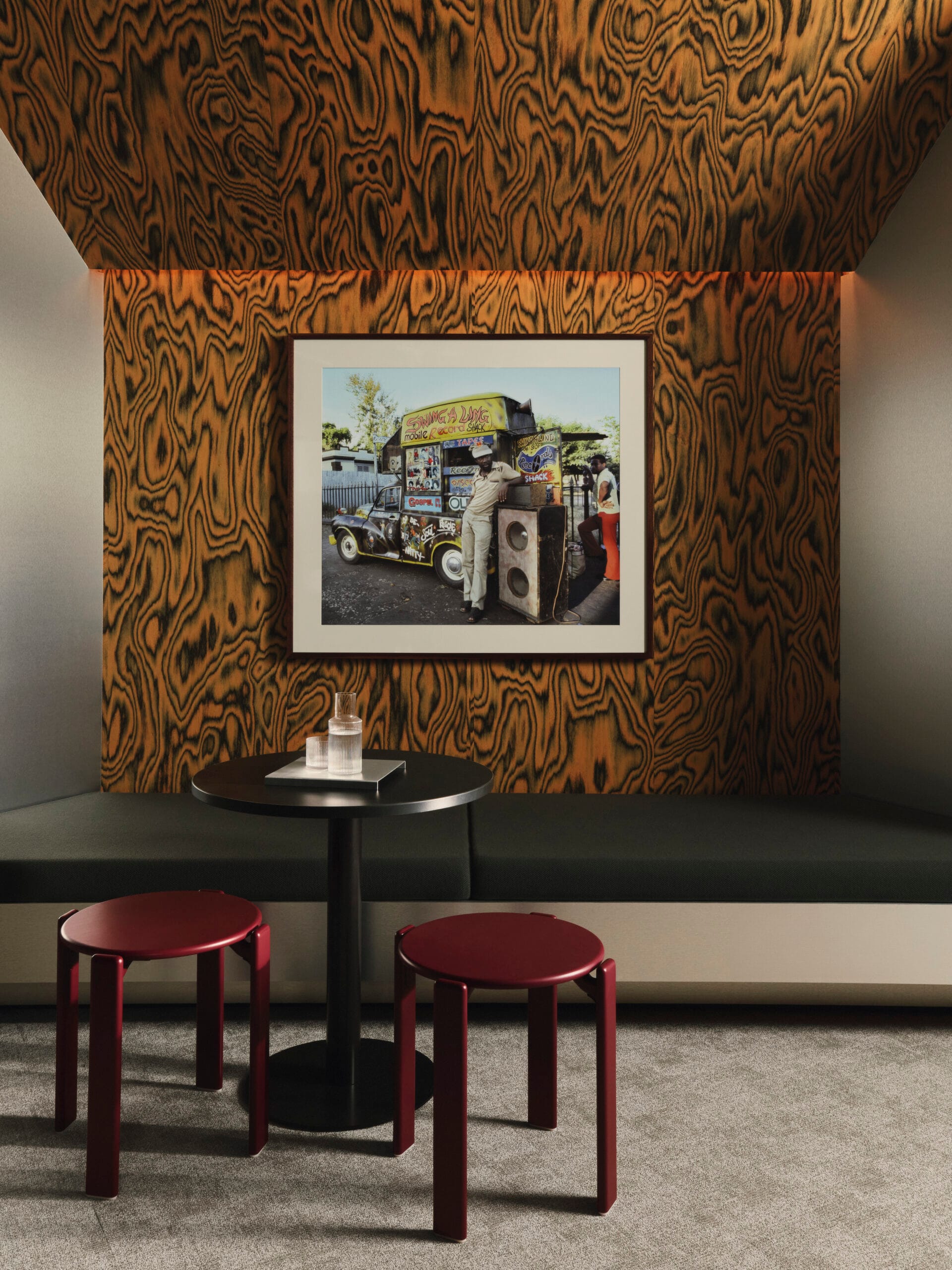 Zitruimte in het kantoor met een ingelijste foto van een mobiele platenzaak tegen een wand van generfd hout