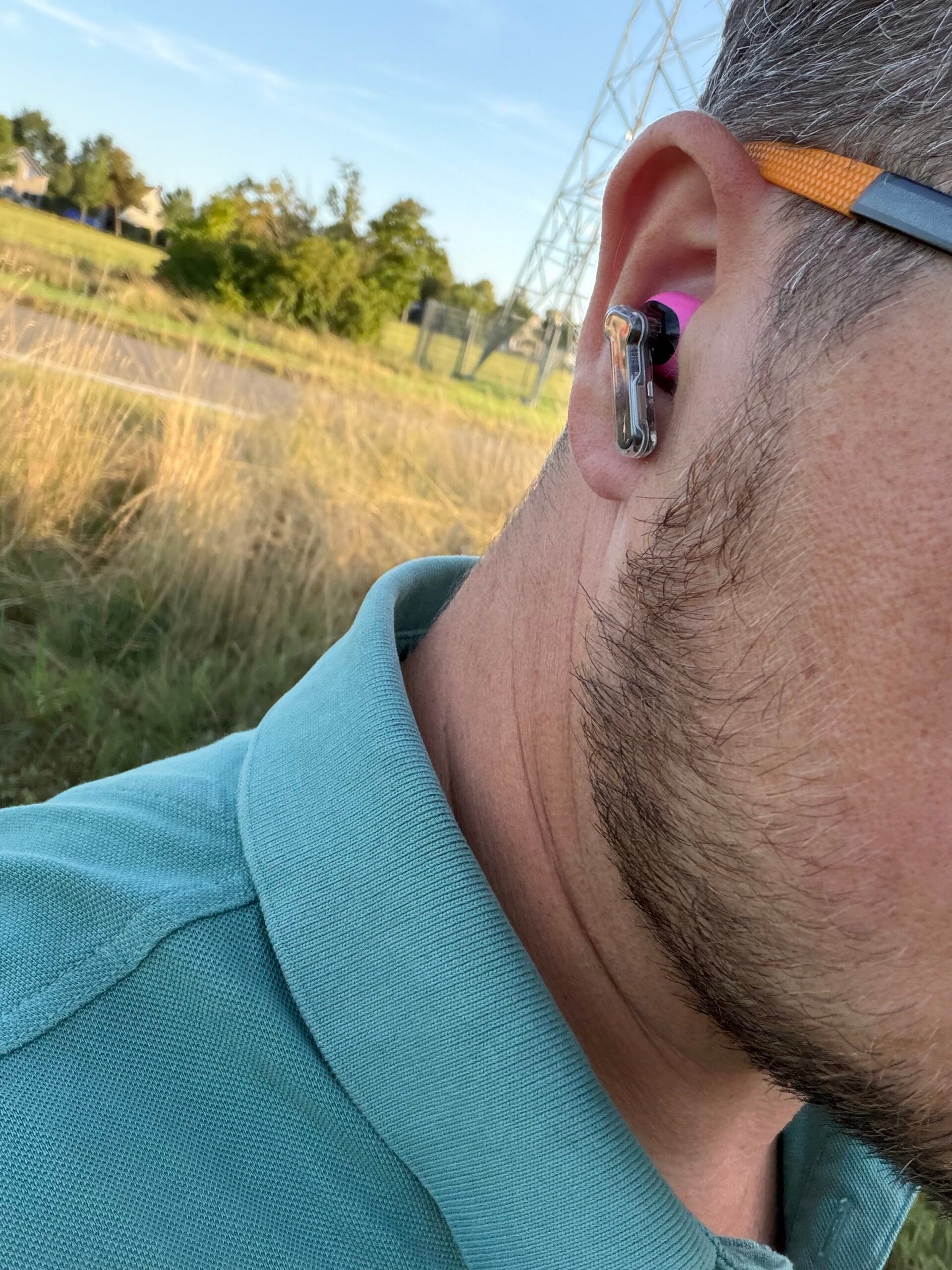 Zijaanzicht van een man die de roze Nothing Ear (3a) oordopjes draagt met het kenmerkende transparante steeltje