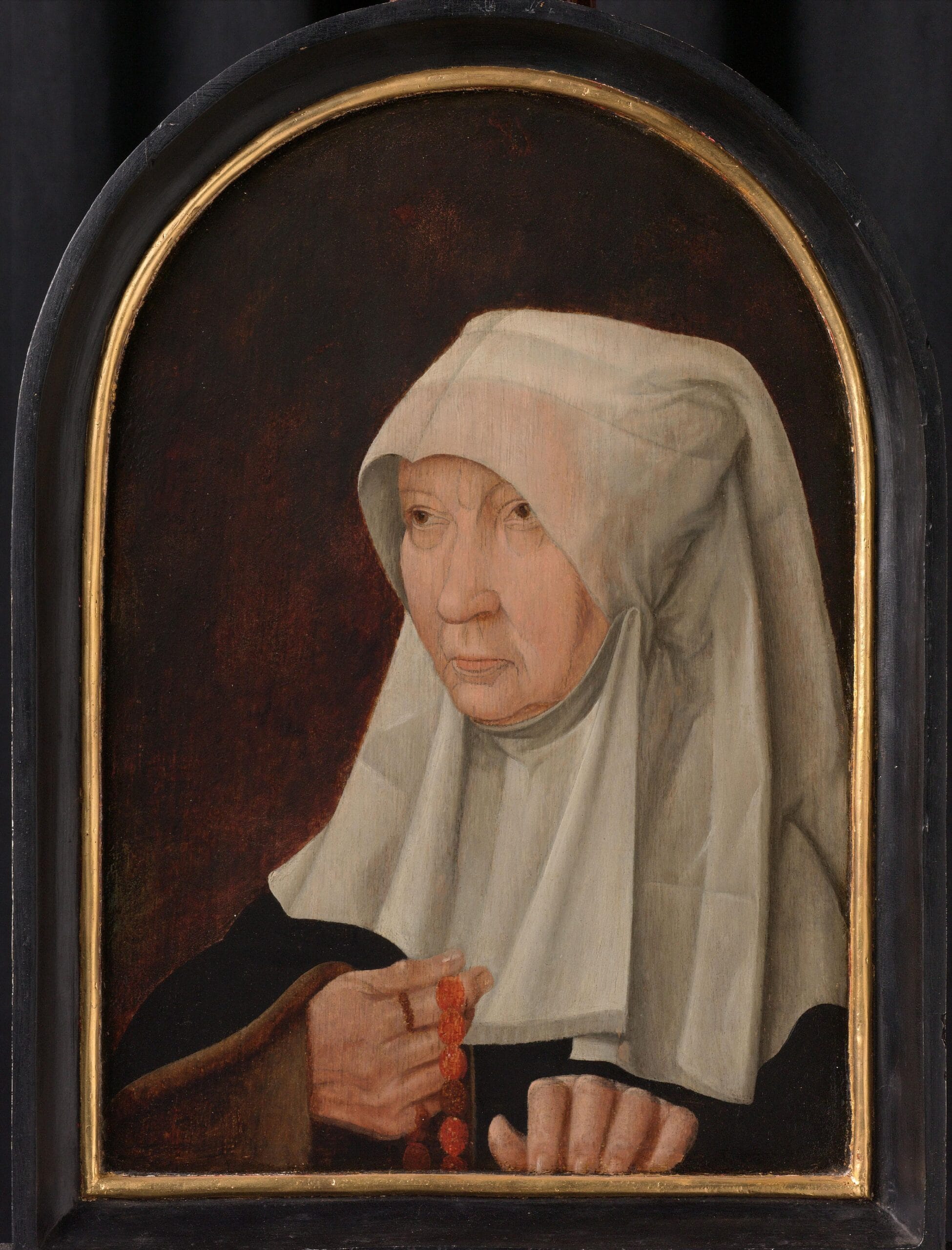 Oudere vrouw in kloostergewaad met een witte hoofddoek en een rozenkrans in haar hand, Portret van Jacomina Claesdr. van Ruyven ca 1550