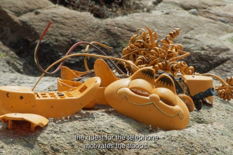 Onderdelen van een kapotte oranje Garfield-telefoon liggen aangespoeld op rotsen aan de kust