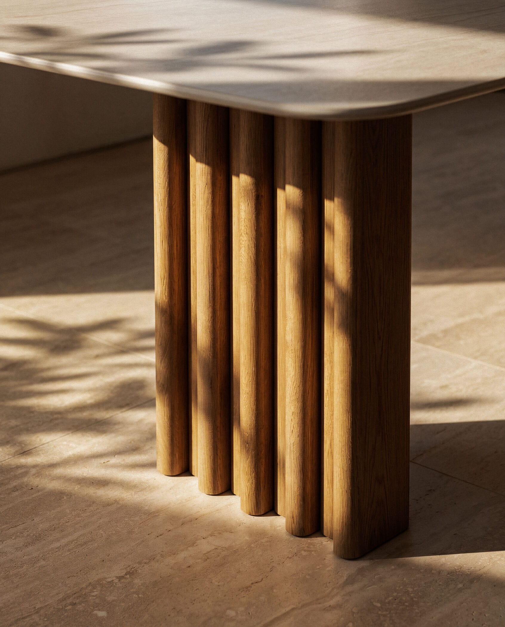 Tafelpoot bestaande uit een rij verticale, ronde houten latten onder een licht tafelblad uit de collectie keramische tafels van Table du Sud