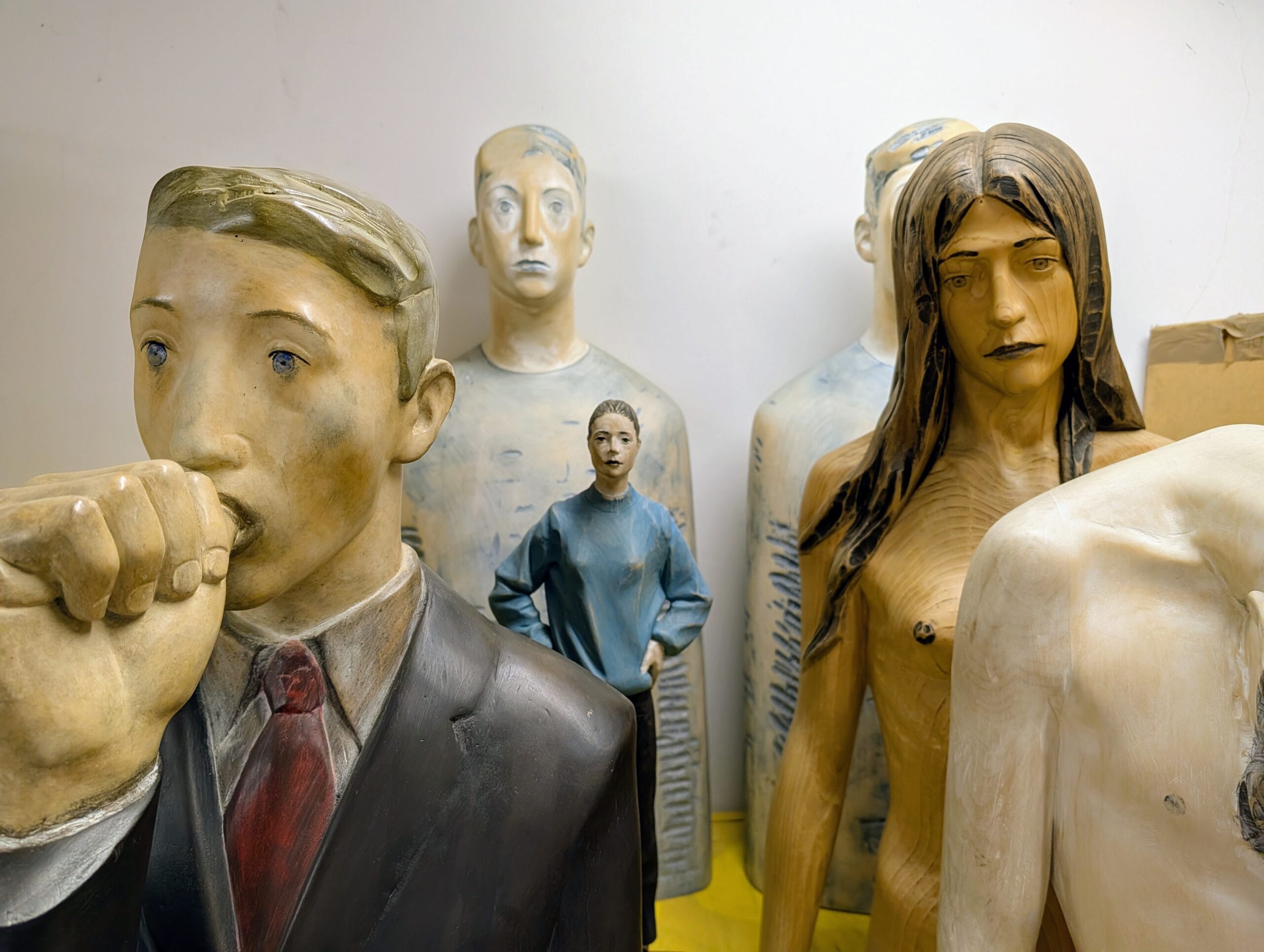 Houten sculpturen van mensfiguren in het atelier van kunstenaar Aron Demetz