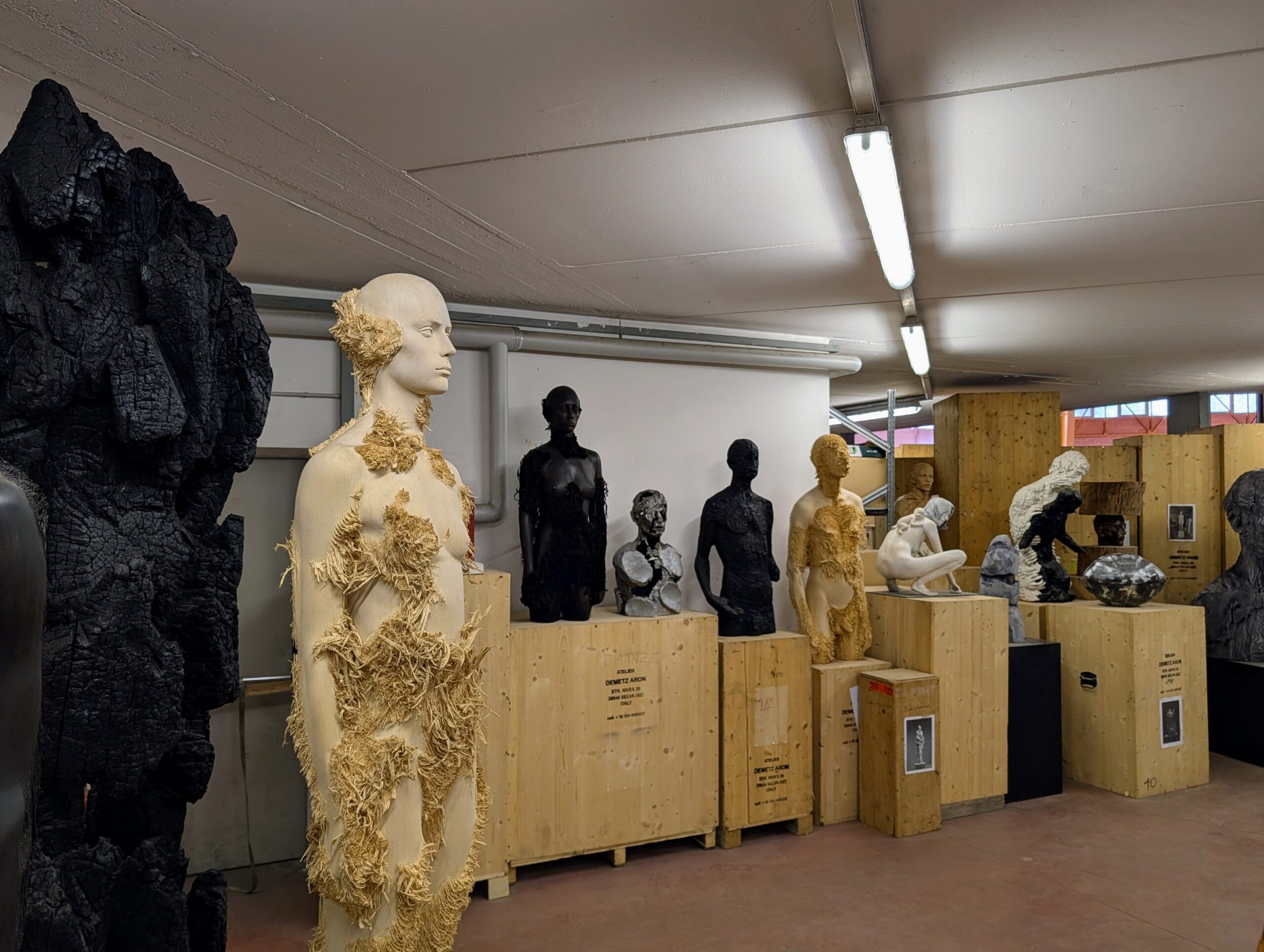Houten en geblakerde menselijke sculpturen opgeslagen in het atelier van kunstenaar Aron Demetz