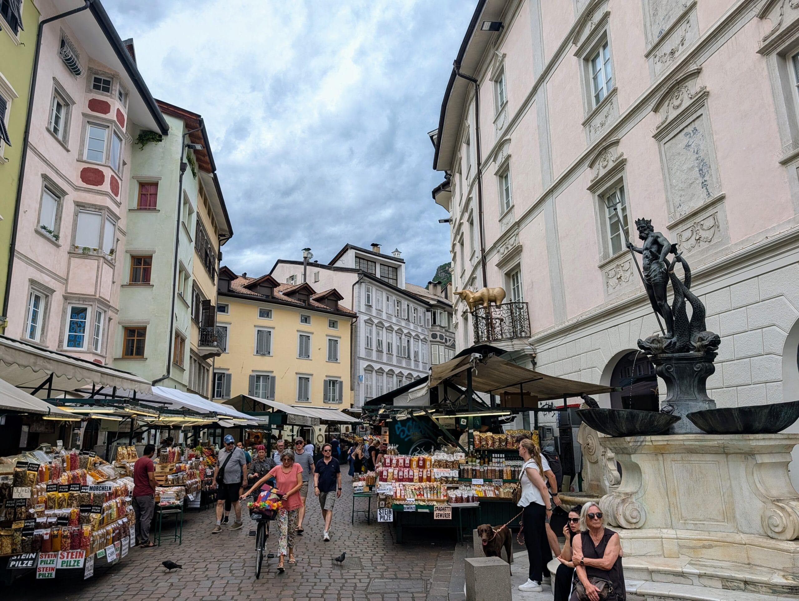 Marktkraampjes met lokale producten en de Neptunusfontein in het historische centrum van Bolzano
