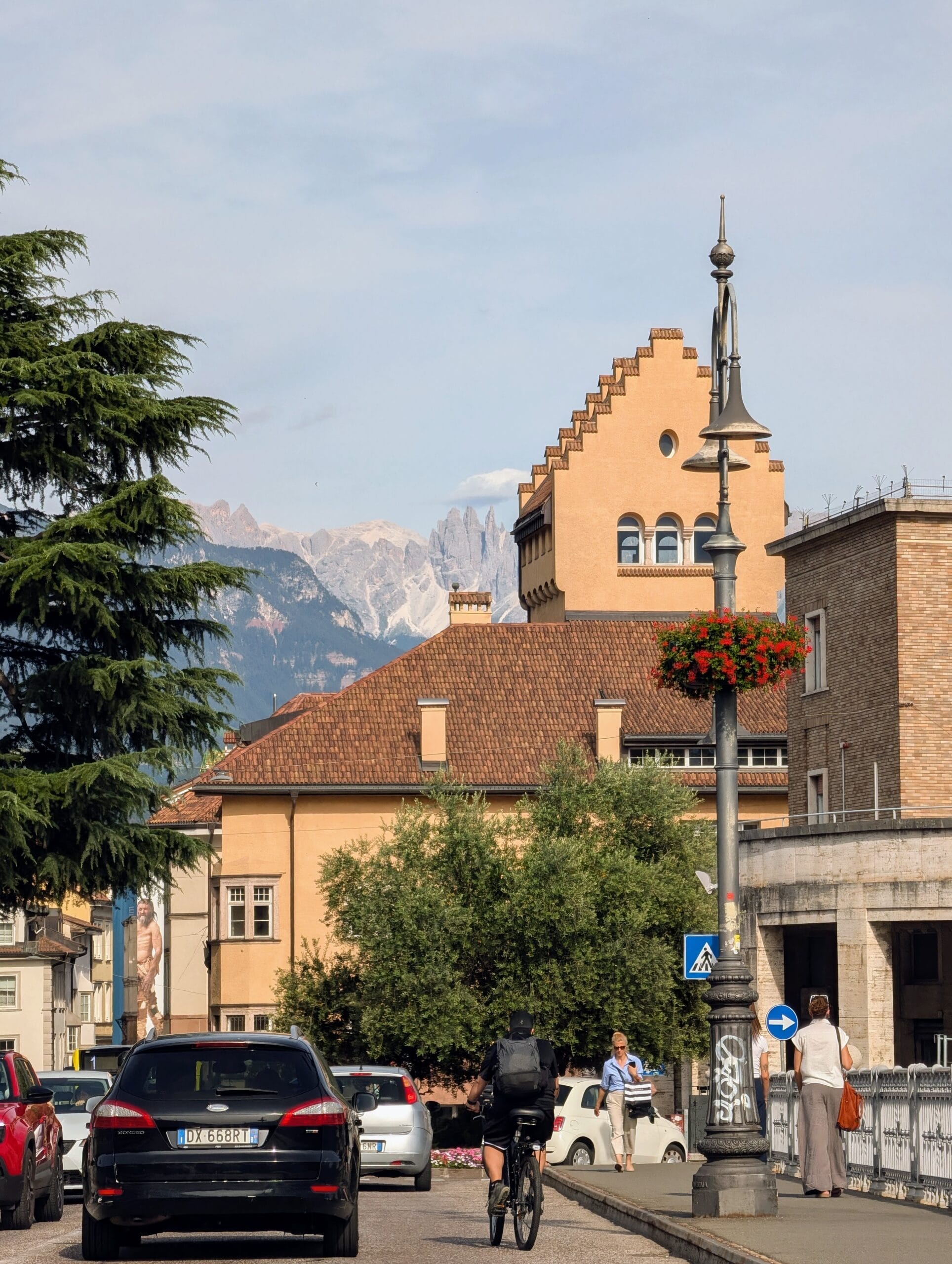 Straatbeeld in Bolzano met historische gebouwen en op de achtergrond de bergtoppen van de Dolomieten