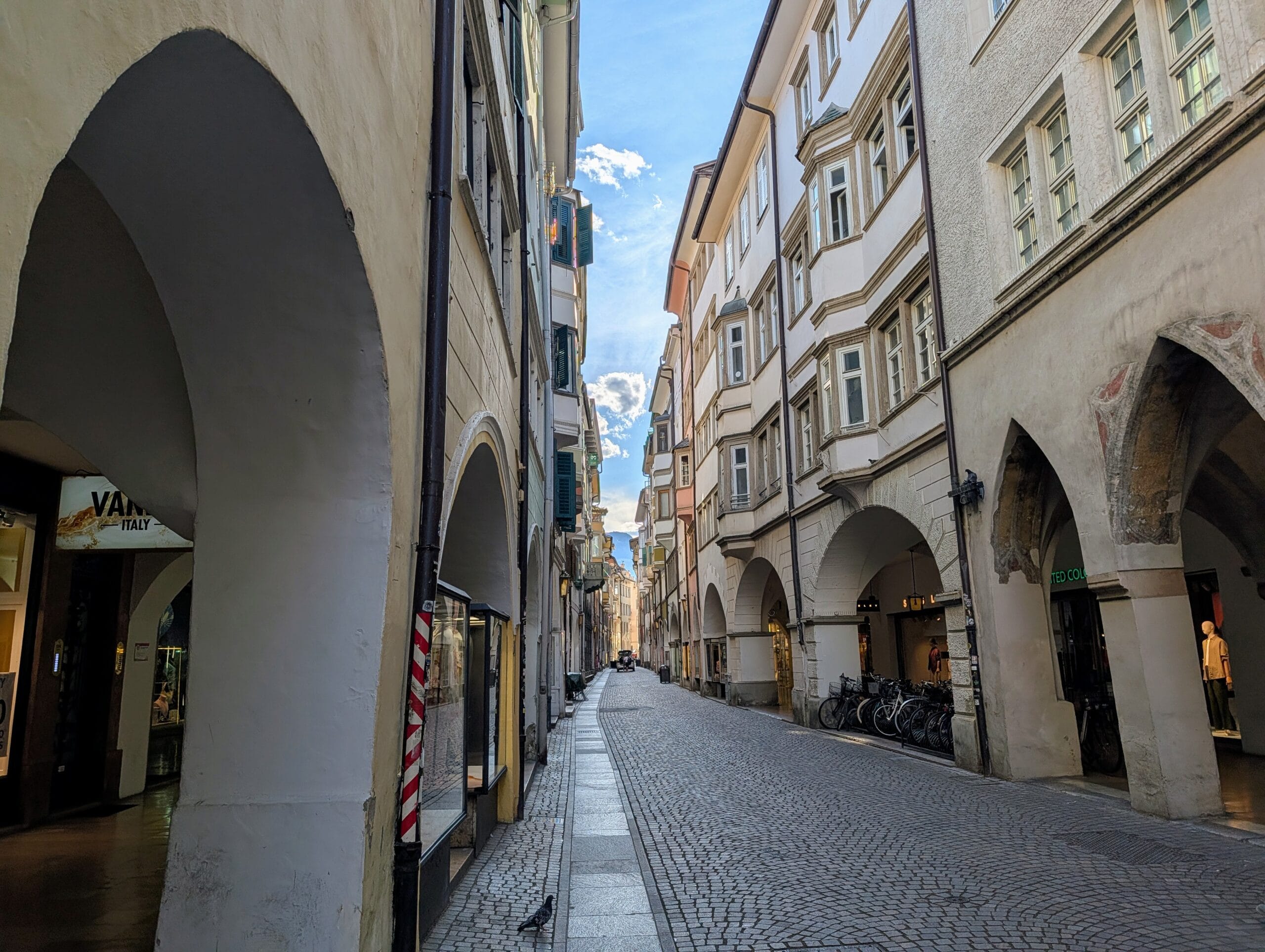 Sfeervolle smalle straat met historische booggalerijen en kinderkopjes in Bolzano