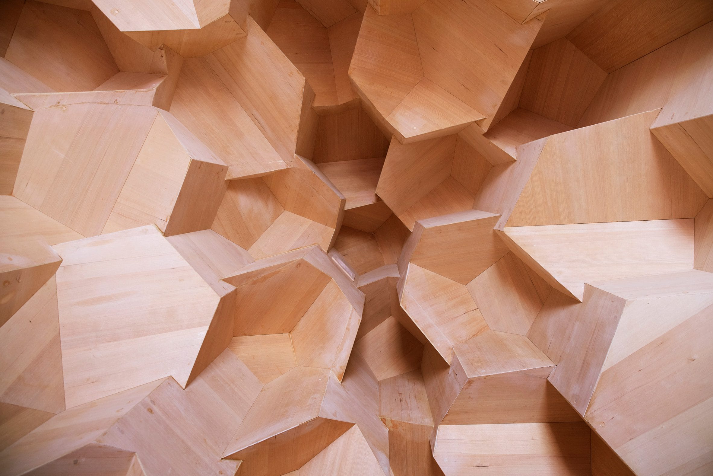 Het houten interieur van de sauna met een geometrische, kristalachtige structuur van elzenhout