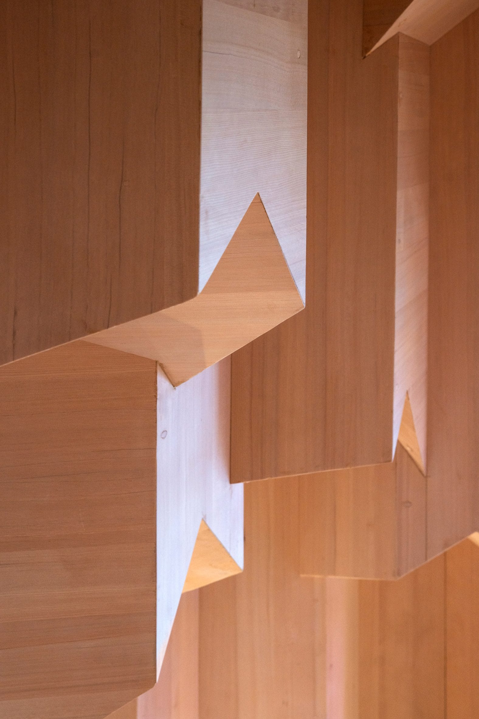 Detail van de houten wanden in de Lithium Crystal Sauna, met geometrische, kristalachtige vormen van elzenhout