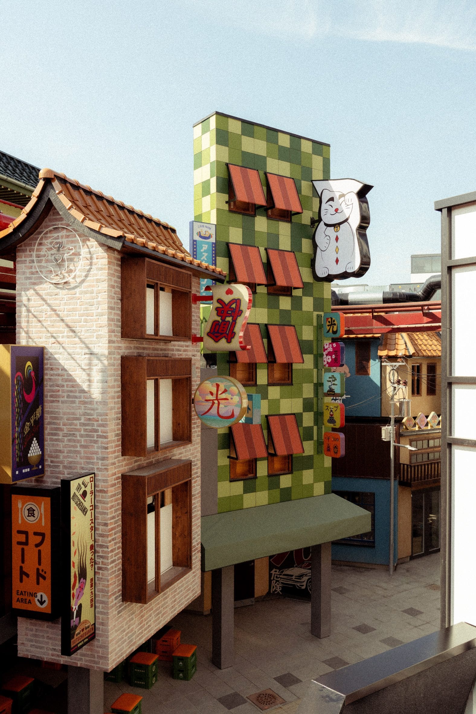 Straatbeeld in themagebied Hikari met Japanse gevels, uithangborden en een grote Maneki-neko gelukskat