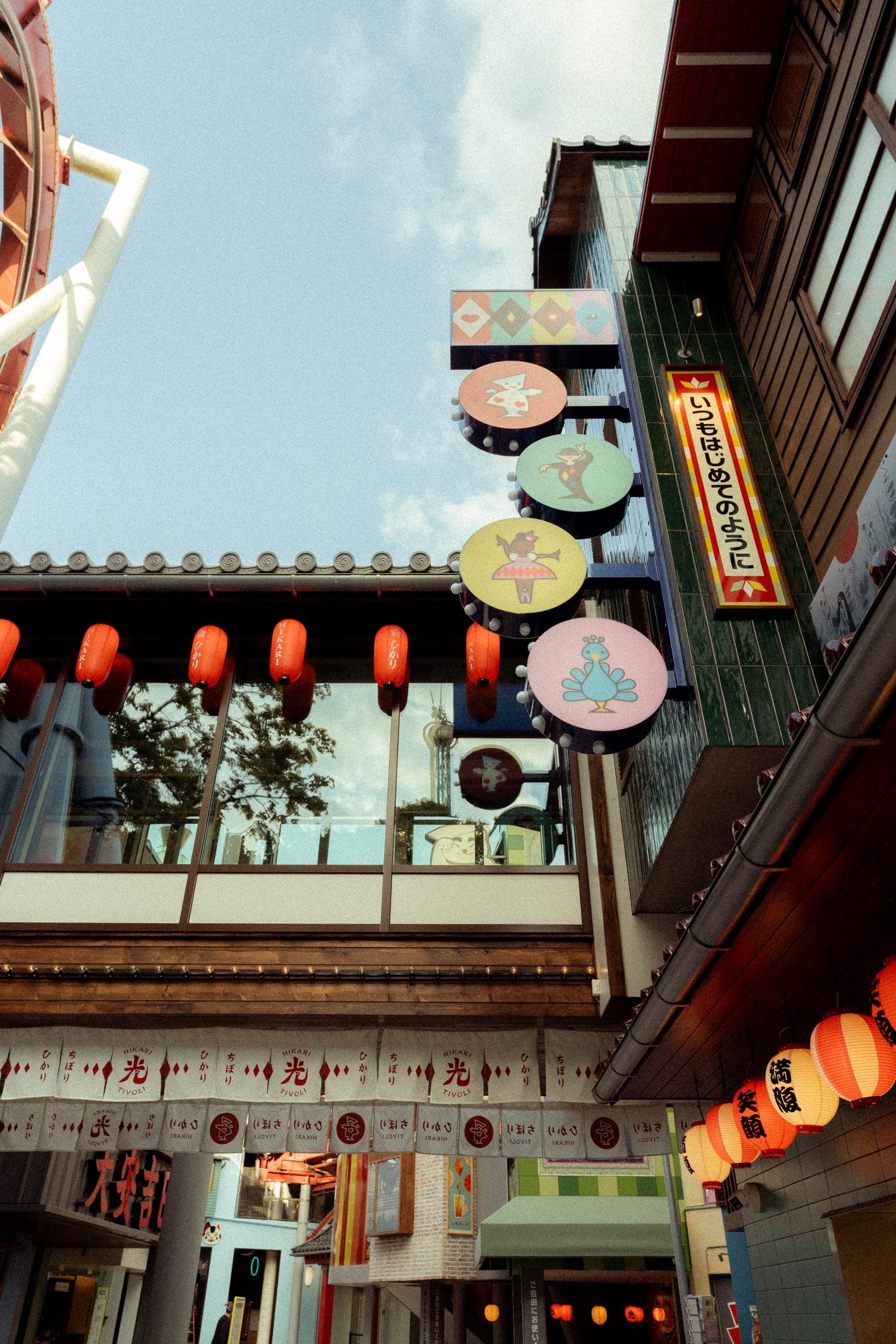 Straatbeeld in het Japanse themagebied Hikari in Tivoli met rode lantaarns, traditionele gevels en kleurrijke uithangborden