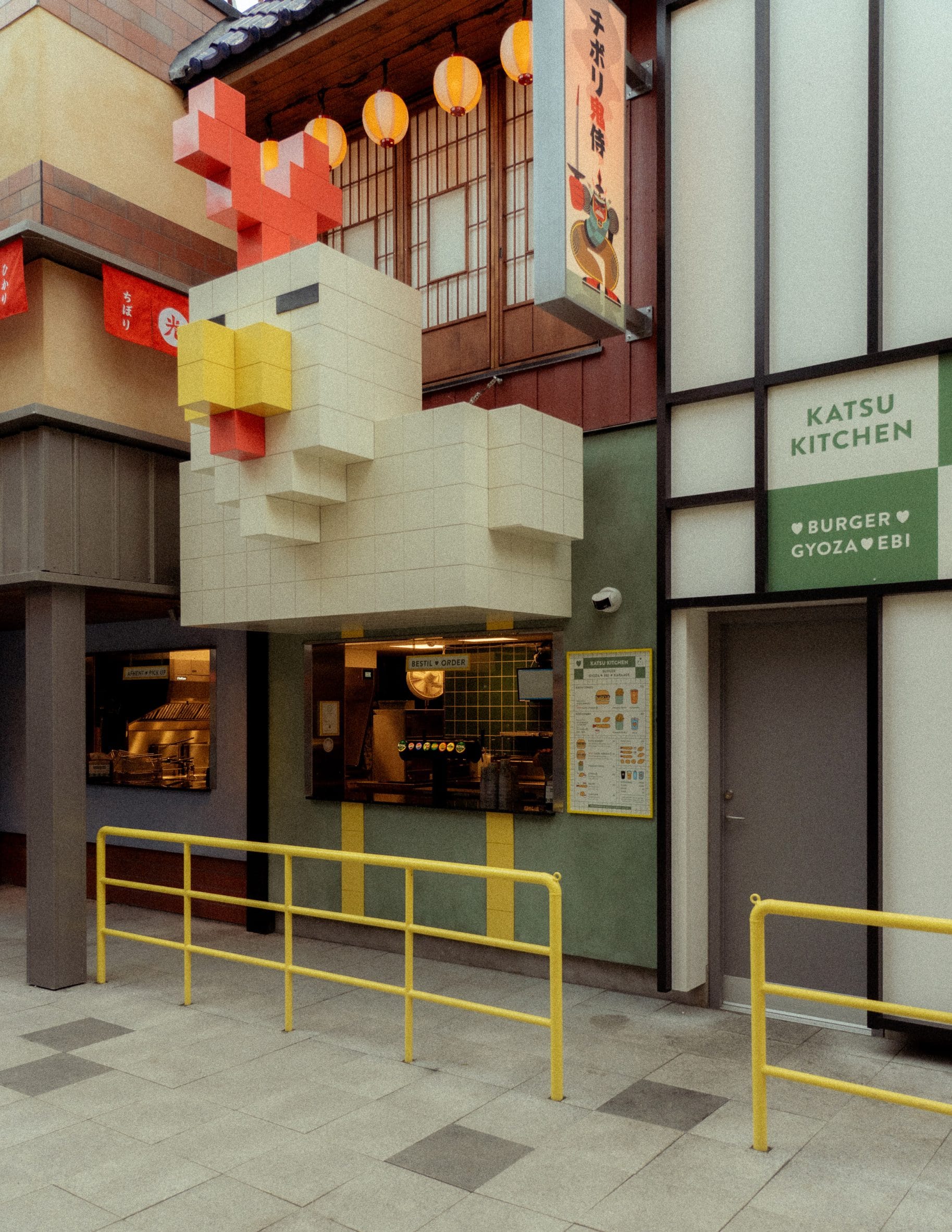 Katsu Kitchen-eetkraam in themagebied Hikari met een grote, gepixelde blokkenkip boven het bestelloket