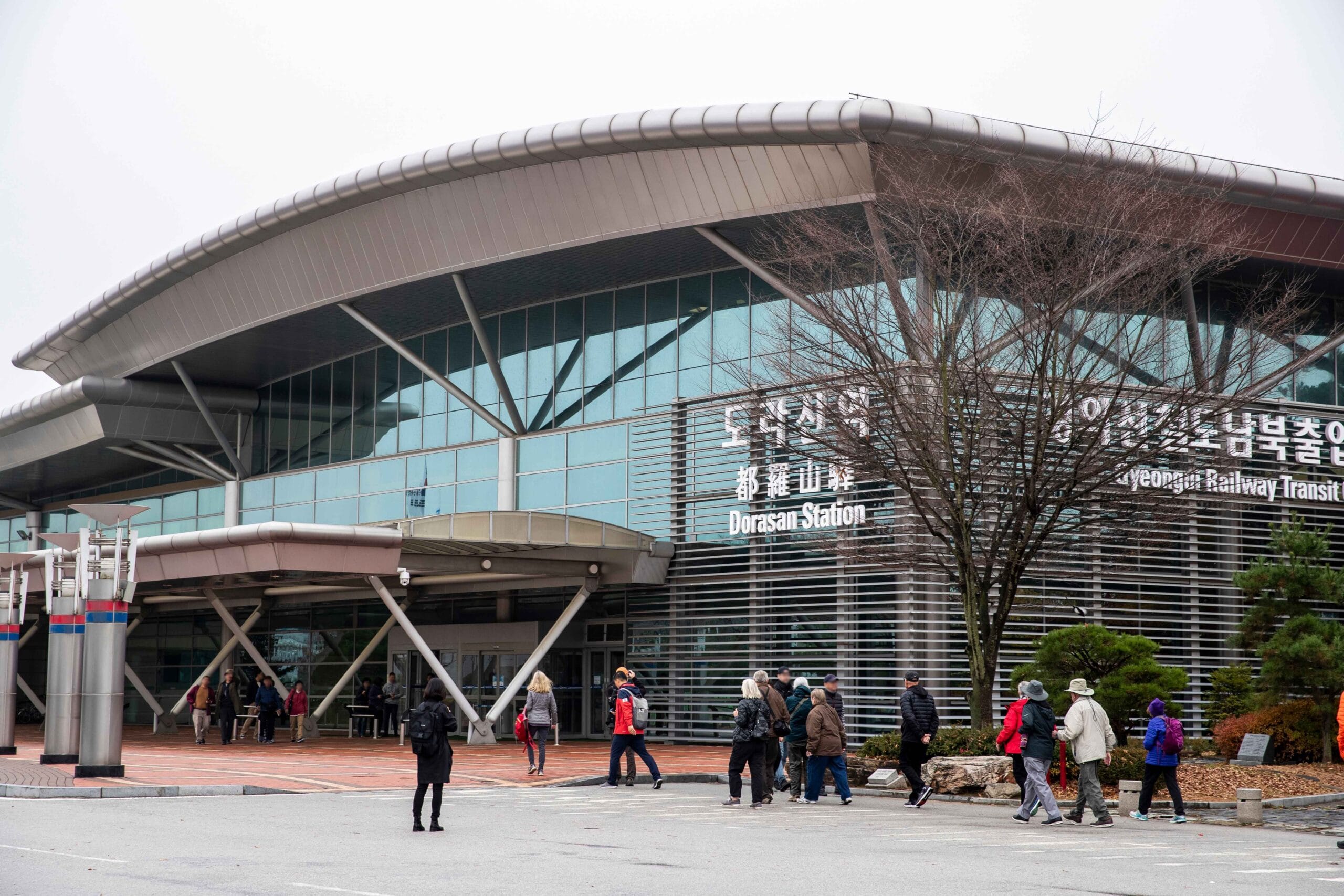 Het moderne glazen stationsgebouw van Dorasan Station met reizigers op het voorplein