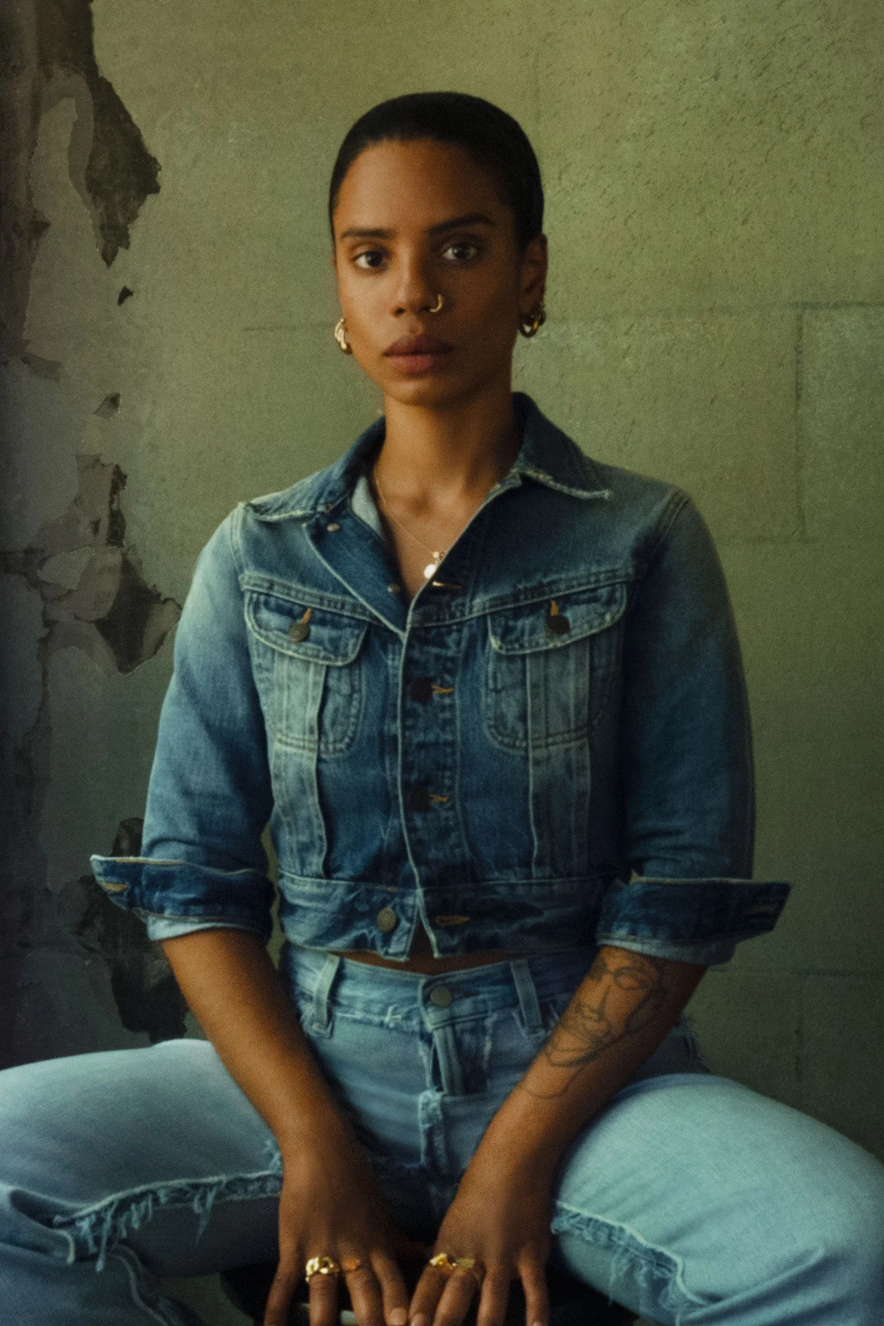Zittend portret van Sandra Poulson gekleed in een kort spijkerjack en een bijpassende jeans