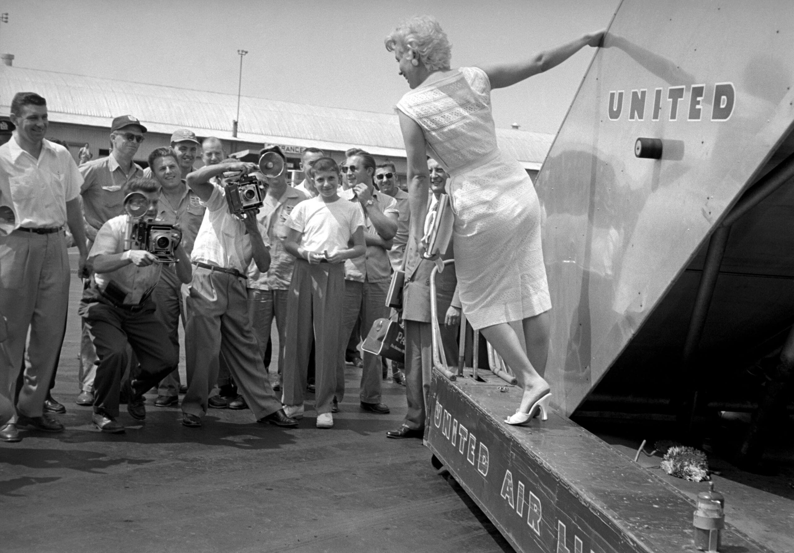 Marilyn Monroe op de vliegtrap van United Airlines, gefotografeerd door toeschouwers en persfotografen, foto van Eve Arnold 1955