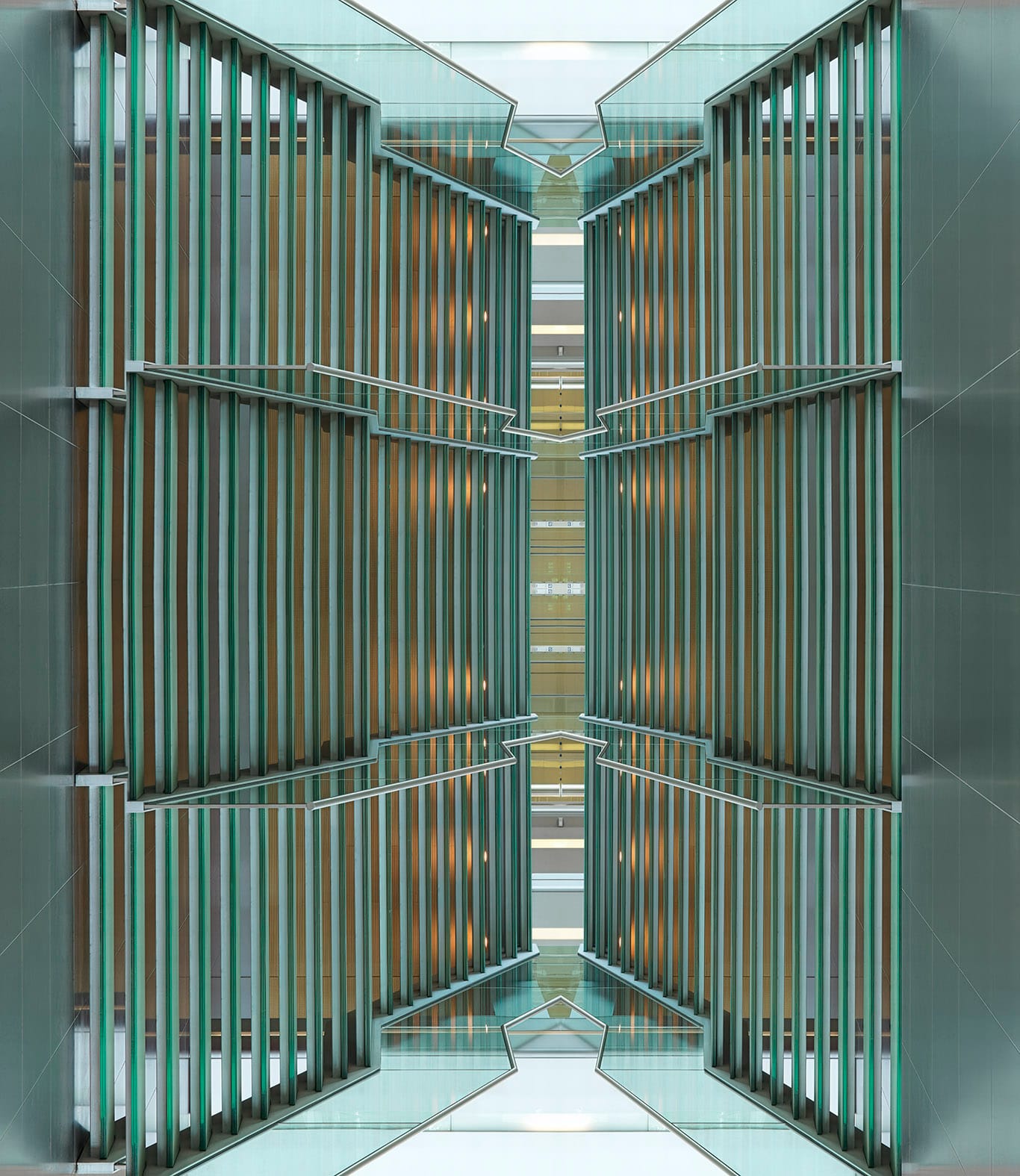 Werk Tresor van Ralf Brueck, Symmetrisch gespiegelde architectuurfoto van een modern interieur met verticale groene glazen lamellen en relingen