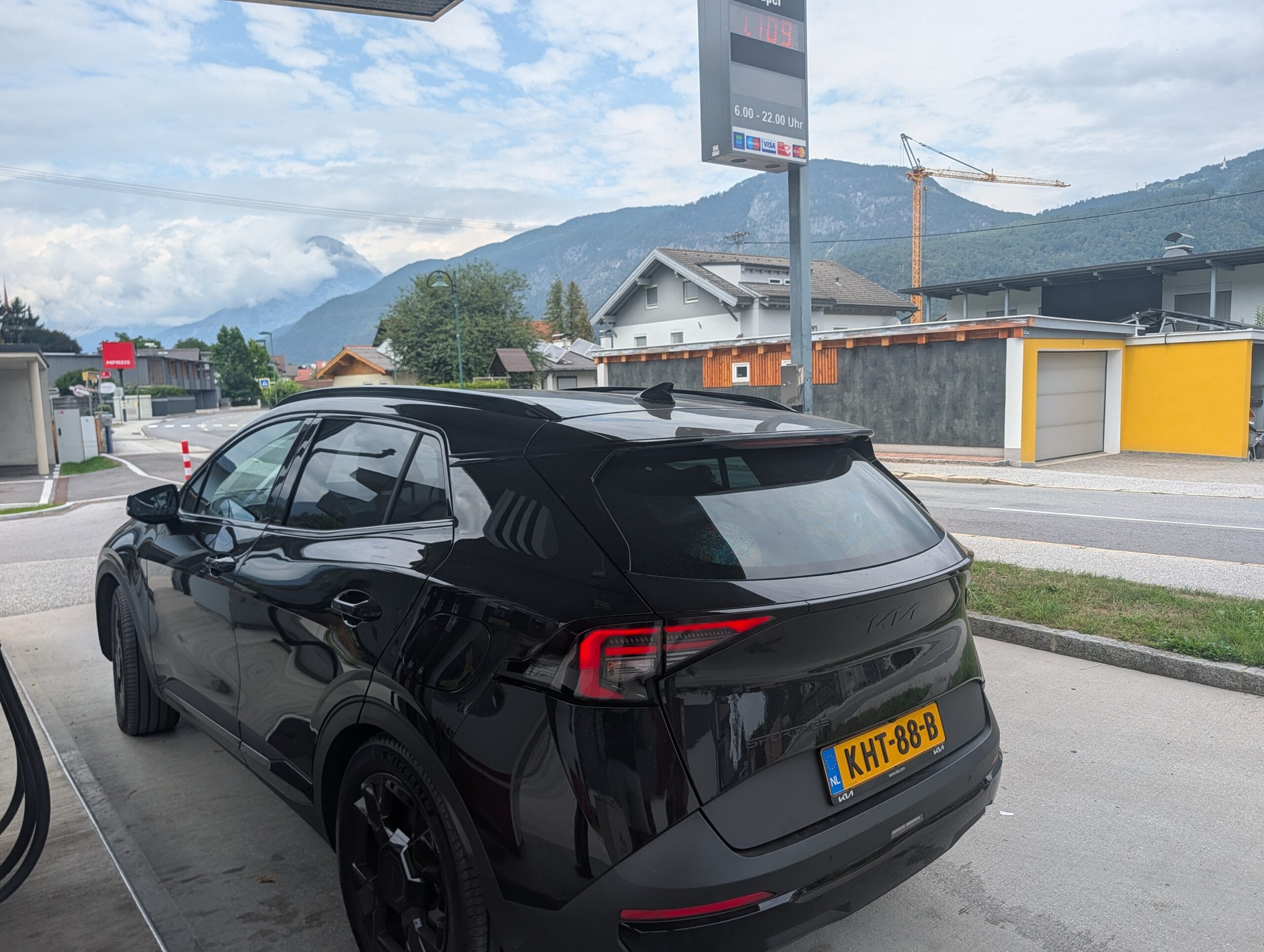 Zwarte Kia Sportage geparkeerd bij een tankstation in een bergachtig Oostenrijks dorp
