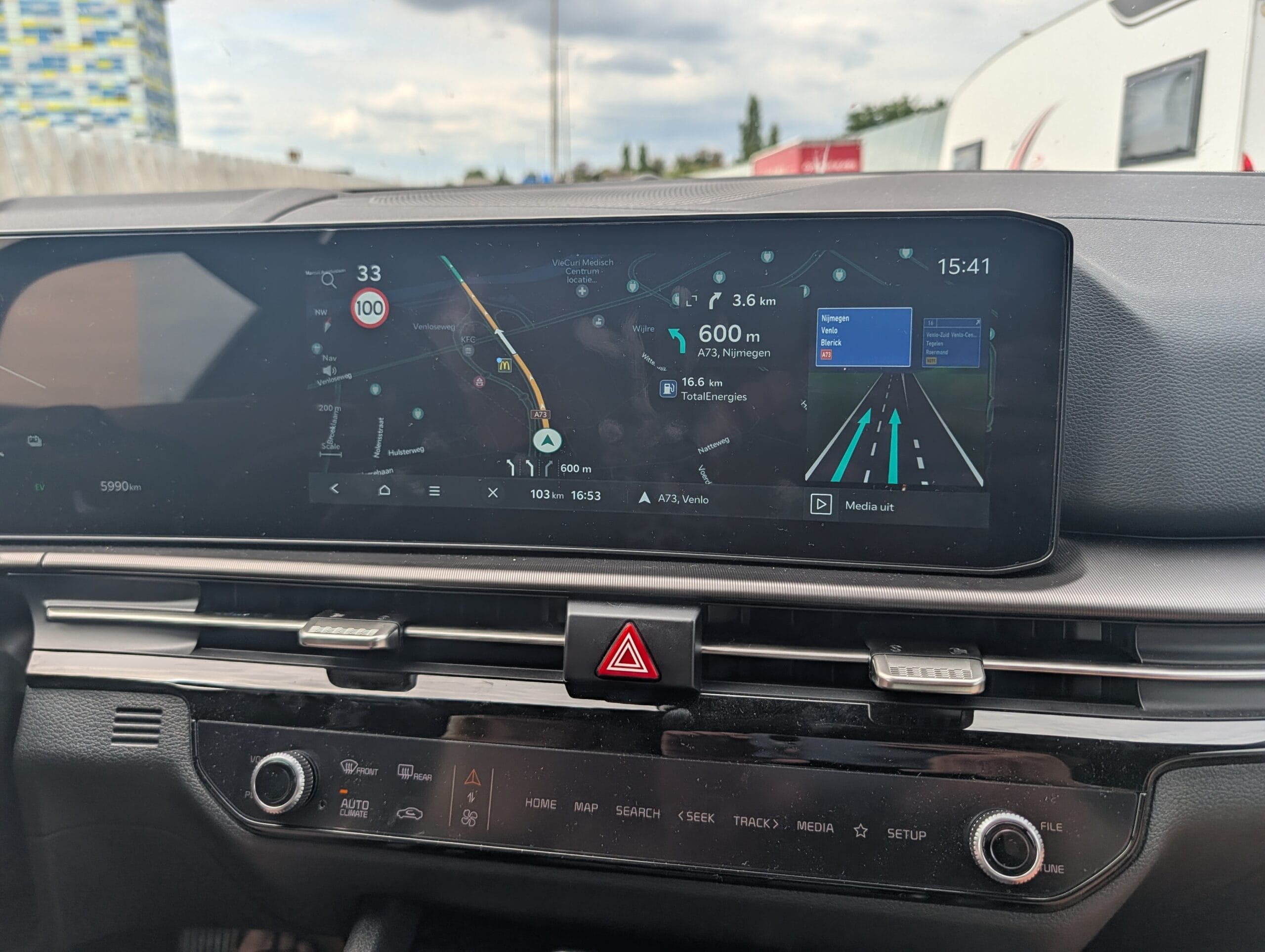 Het infotainmentscherm van de Kia Sportage toont navigatie met rijbaanbegeleiding richting de A73 naar Nijmegen