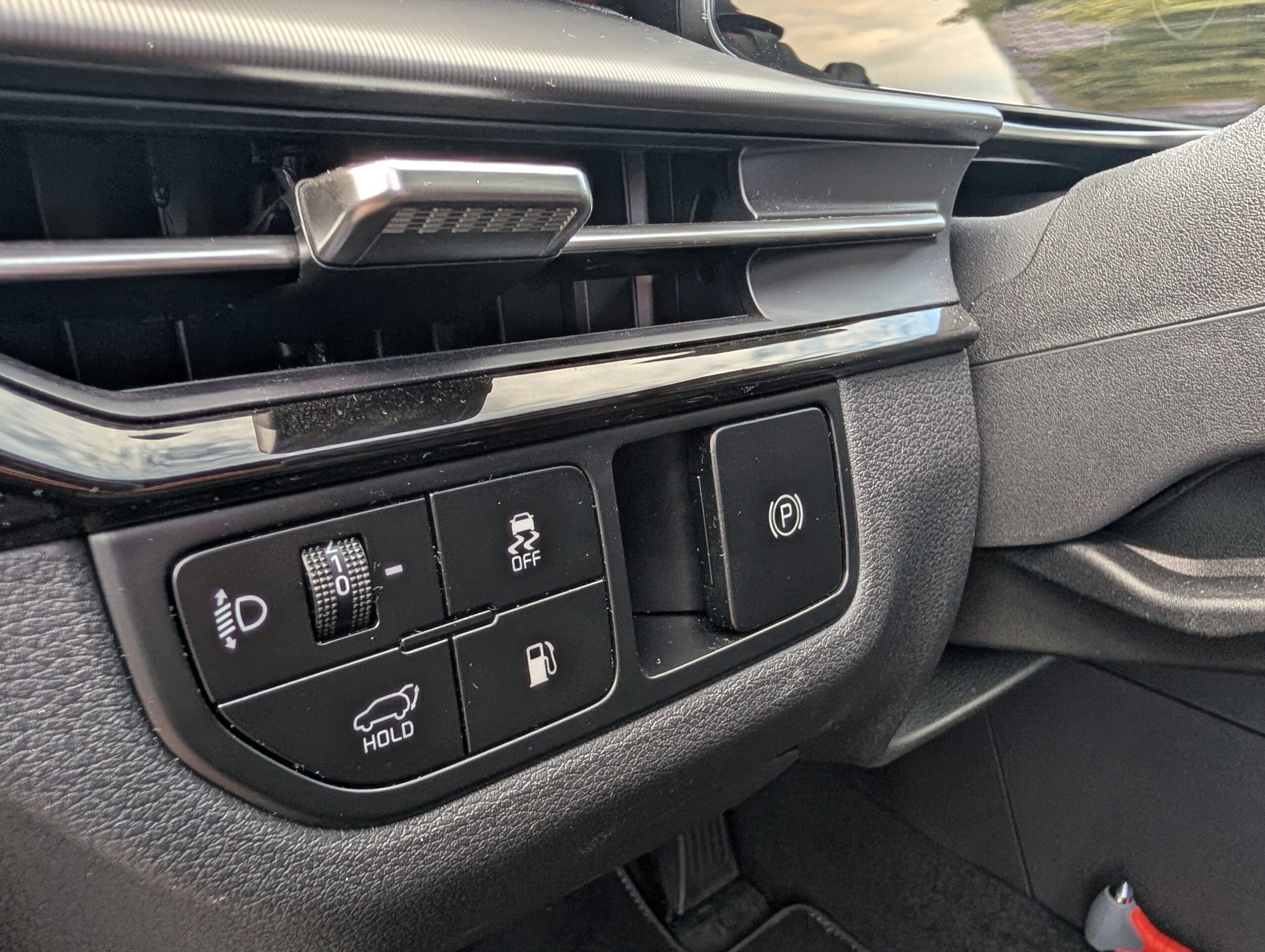 Knoppenpaneel in het dashboard van de Kia Sportage met onder andere de elektronische handrem en tankklepbediening