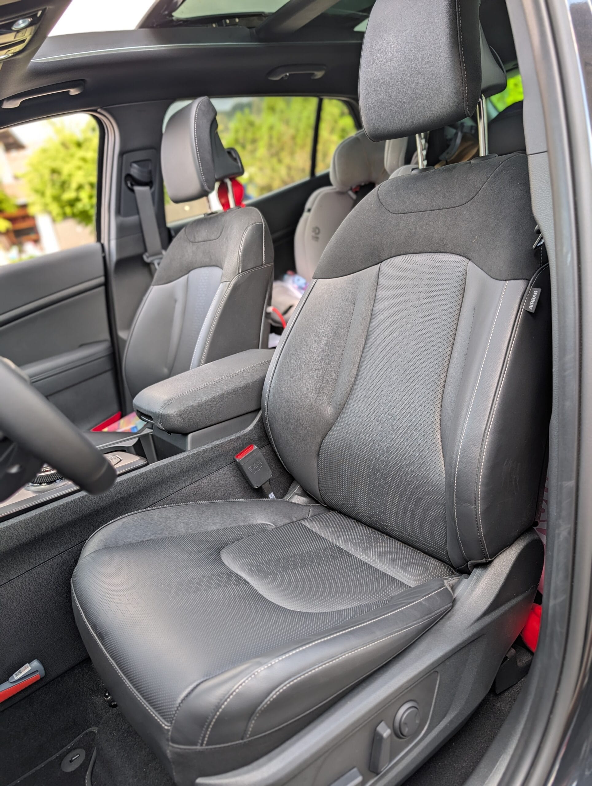 Zwart lederen voorstoel en interieur van de Kia Sportage met uitzicht op de achterbank