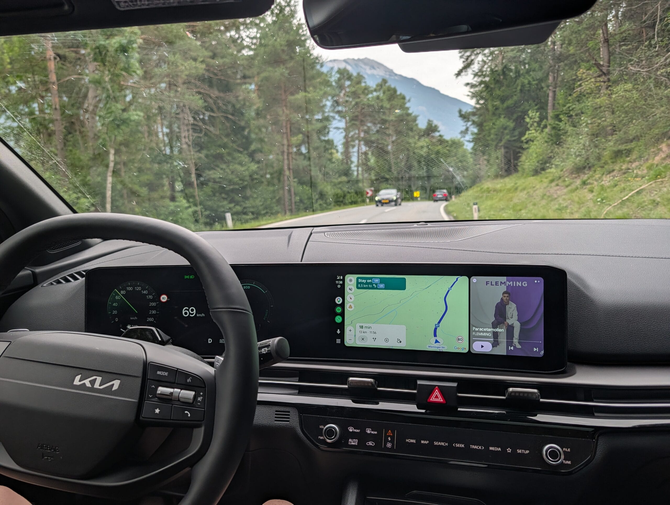 Dashboard en infotainmentscherm van de Kia Sportage tijdens een rit over een bergweg