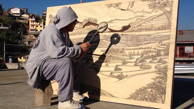 Jordan Mang-Osan tekent met de zon en een vergrootglas
