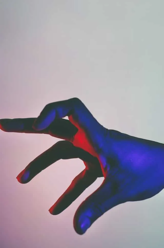 een hand in gekleurd licht